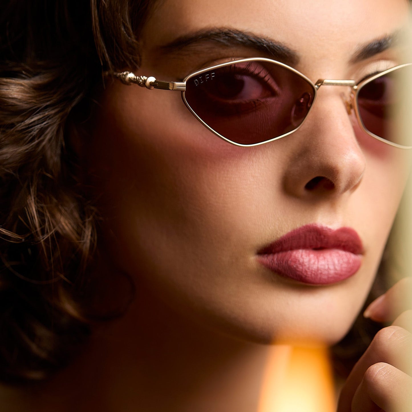 lifestyle - female wearing harry potter x diff eyewear featuring professor dumbledore sunglasses with a gold frame and aubergine lenses angled view