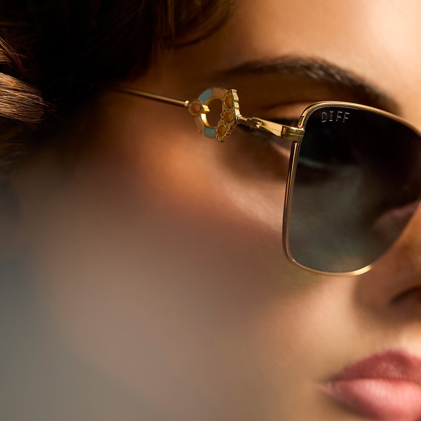 lifestyle - female wearing harry potter x diff eyewear featuring professor mcgonagall cat eye sunglasses with a gold frame and g15 lenses detailed view