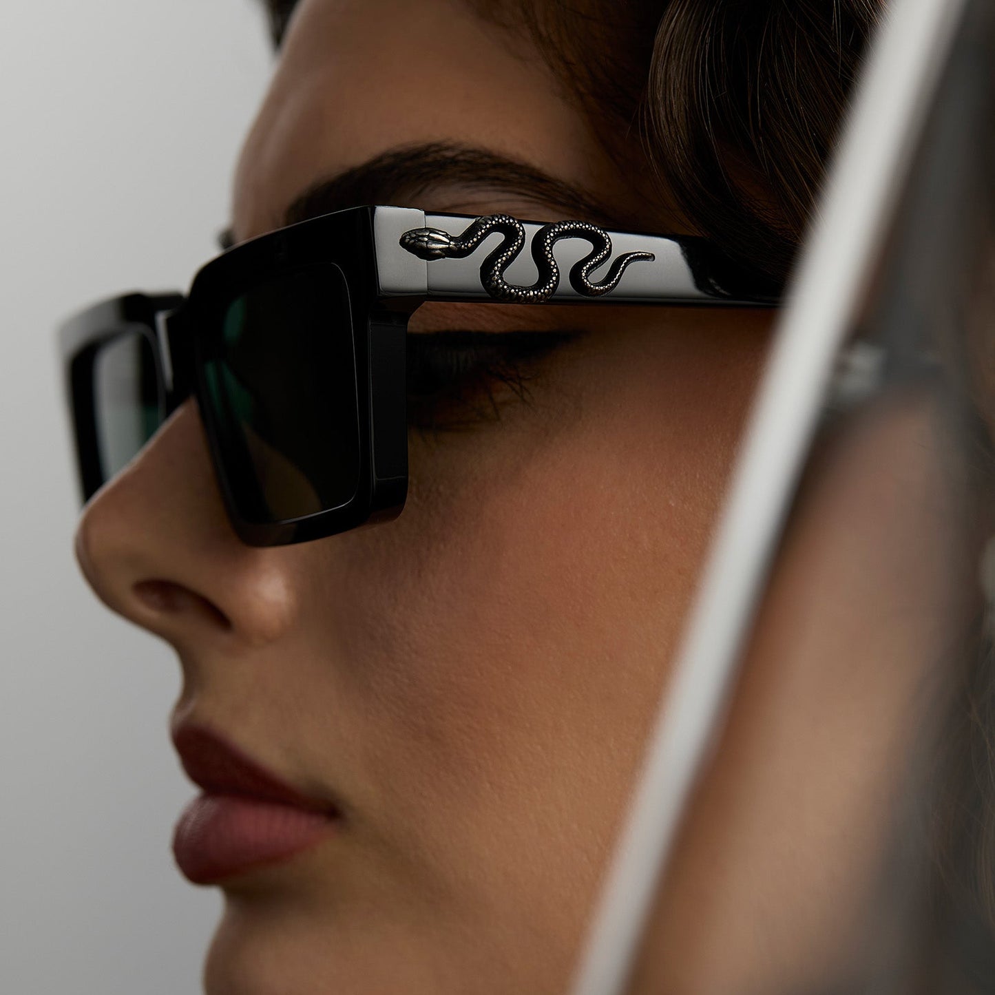 lifestyle - female wearing harry potter x diff eyewear featuring professor snape 2.0 square sunglasses with a black frame and g15 lenses detailed temple view