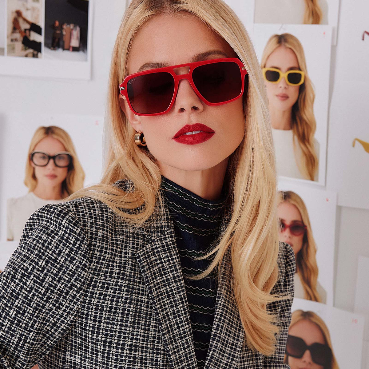 lifestyle - female in photo studio trying on emily in paris x diff eyewear featuring the julien navigator sunglasses with a rouge vogue red frame and warm brown gradient lenses front view