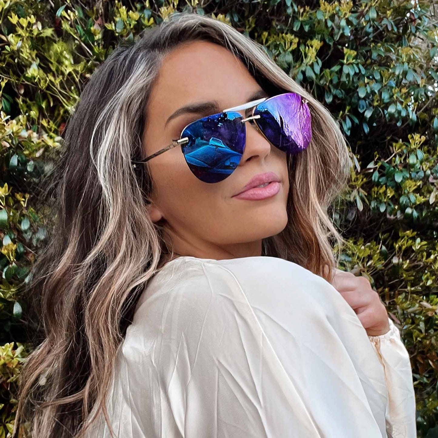 lifestyle - female wearing diff eyewear tahoe aviator sunglasses with a gold frame and purple mirror lenses