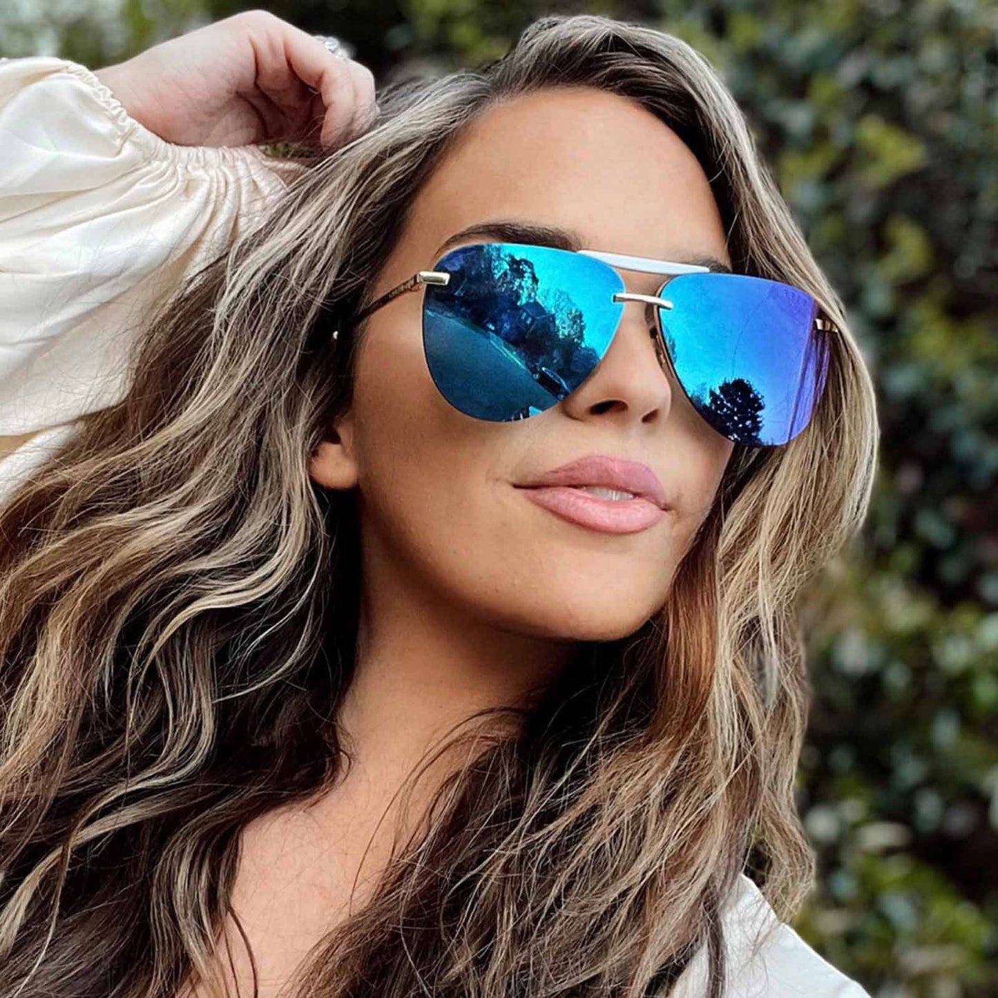lifestyle - female wearing diff eyewear tahoe aviator sunglasses with a gold frame and purple mirror lenses