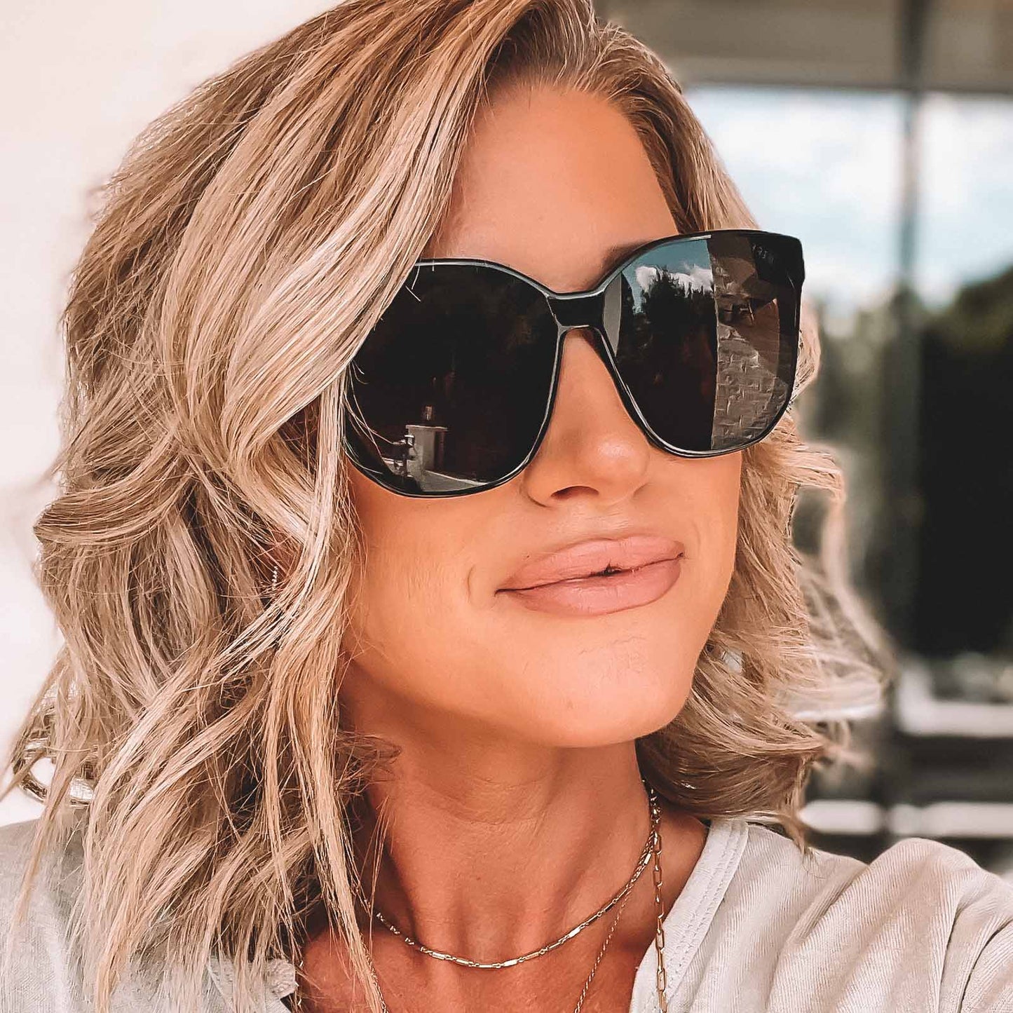lifestyle - female wearing diff eyewear gia square sunglasses with a black frame and grey lenses