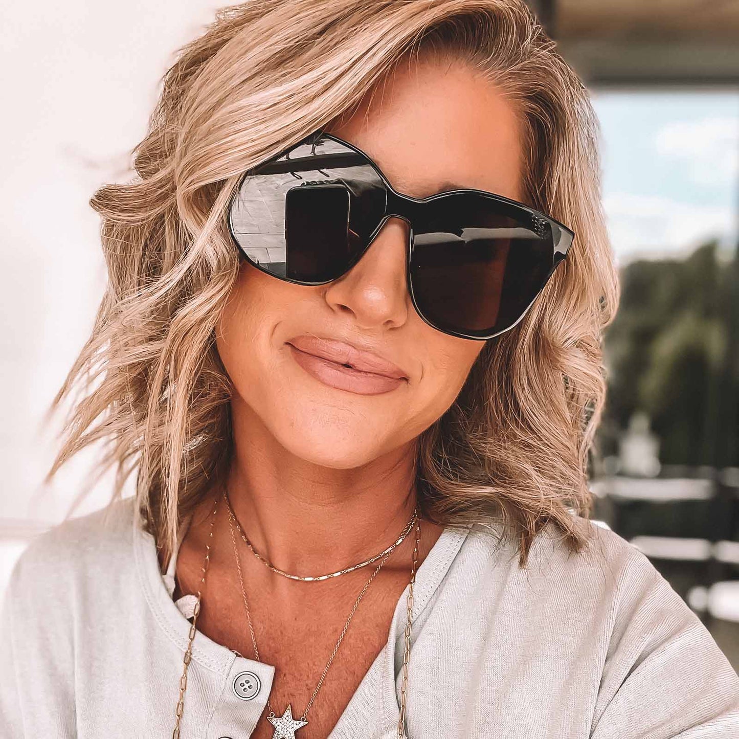lifestyle - female wearing diff eyewear gia square sunglasses with a black frame and grey lenses