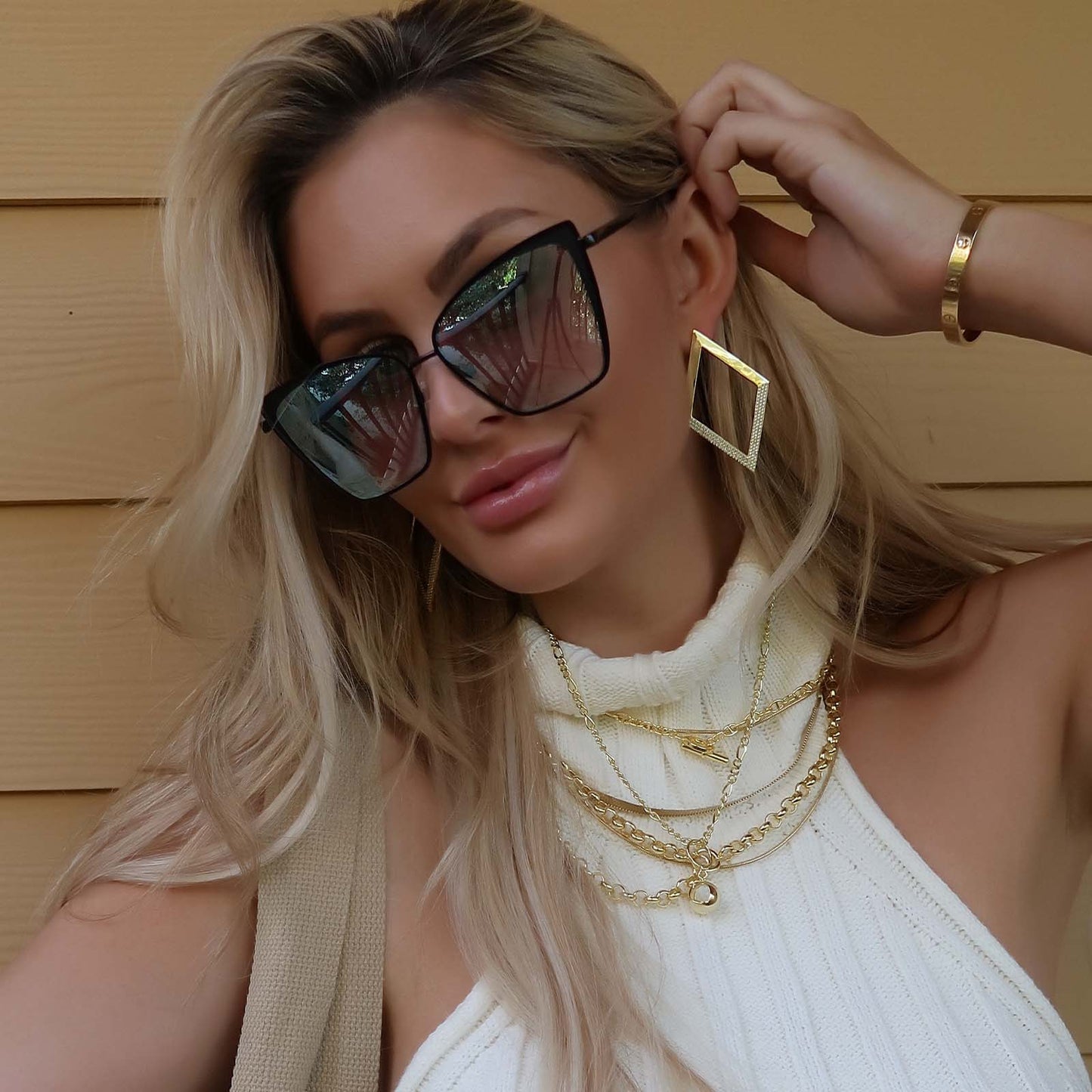 lifestyle - blonde female wearing diff eyewear becky cat eye sunglasses with a black frame and flash grey gradient lenses
