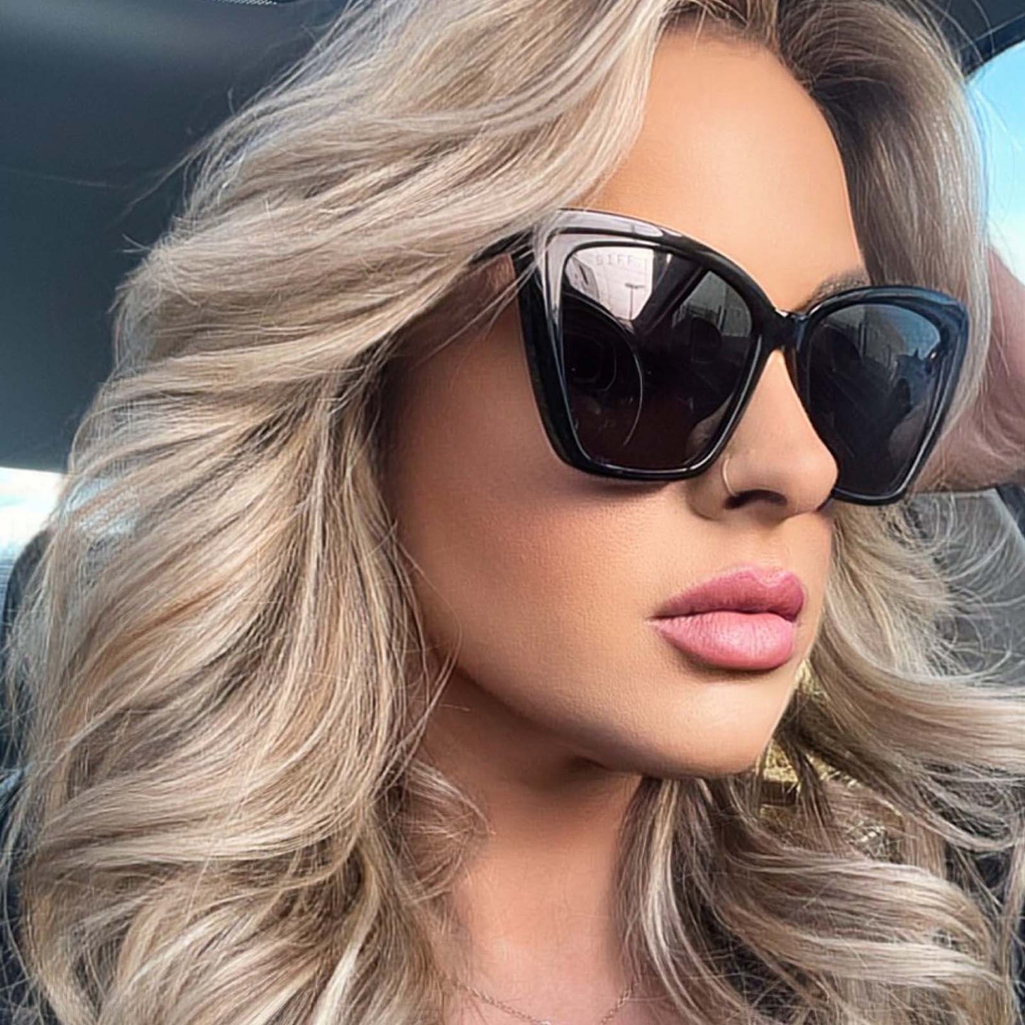 lifestyle - blonde female wearing diff eyewear becky ii black frame dark smoke polarized sunglasses