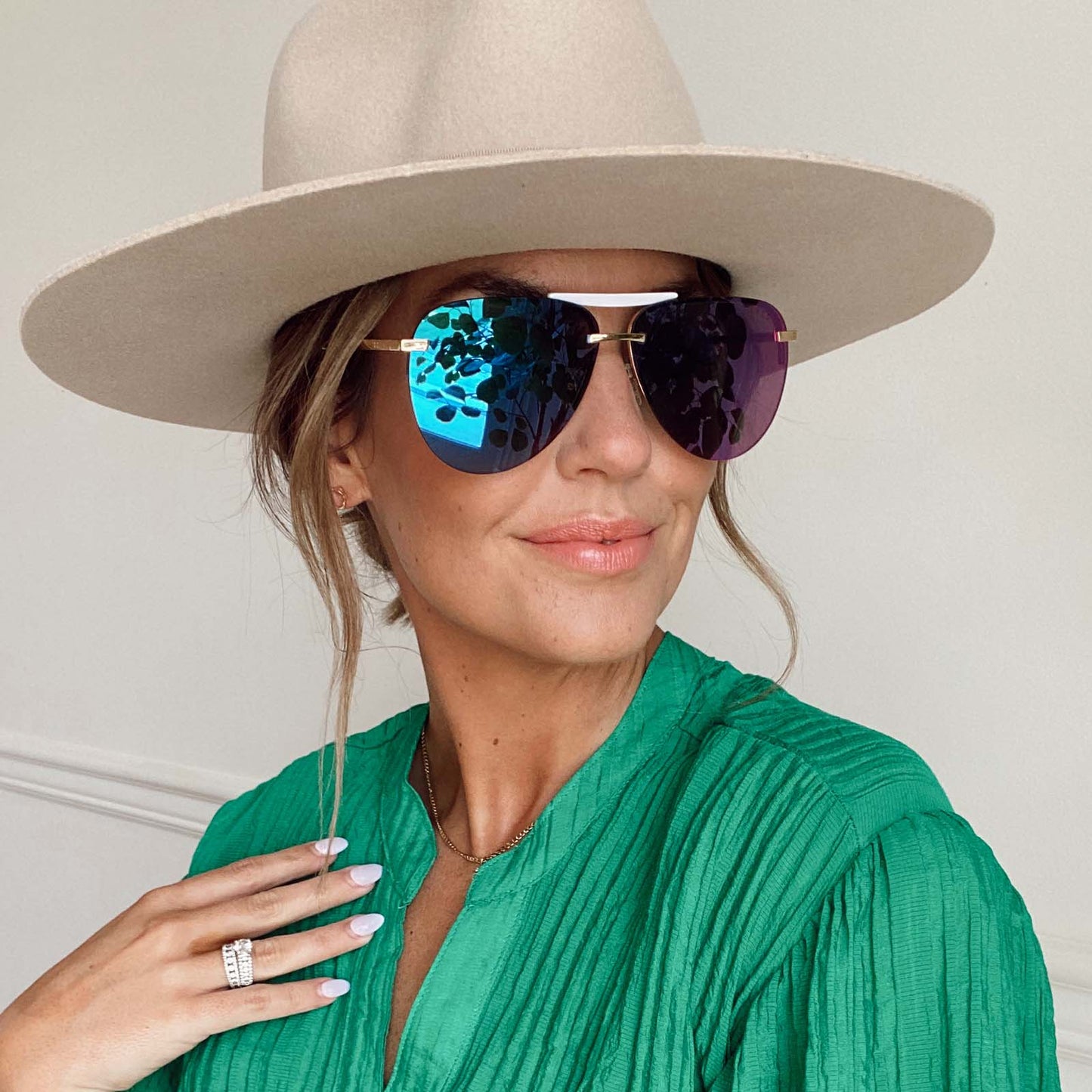customer content - female wearing a hat and diff eyewear tahoe aviator sunglasses with a gold frame and purple mirror lenses