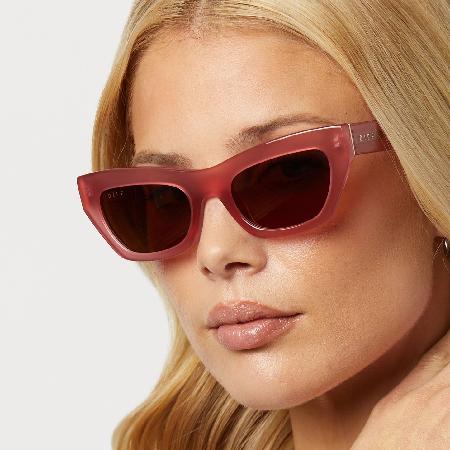 on model - female wearing diff eyewear featuring the katarina cat eye sunglasses with a guava pink frame and brown lenses detailed view