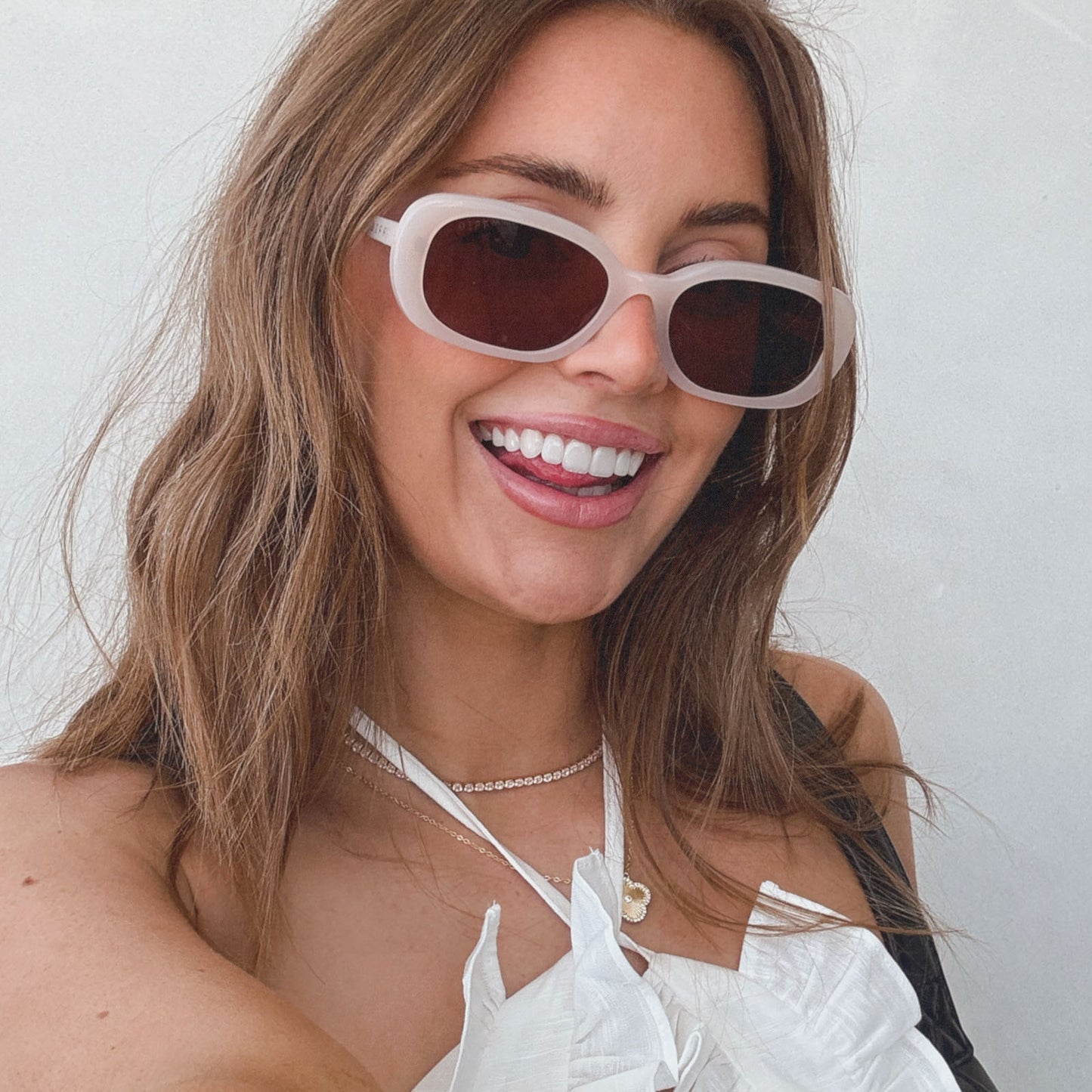 lifestyle - aspyn ovard x diff eyewear female wearing the cove oval sunglasses with a milky blush frame and brown lenses front view