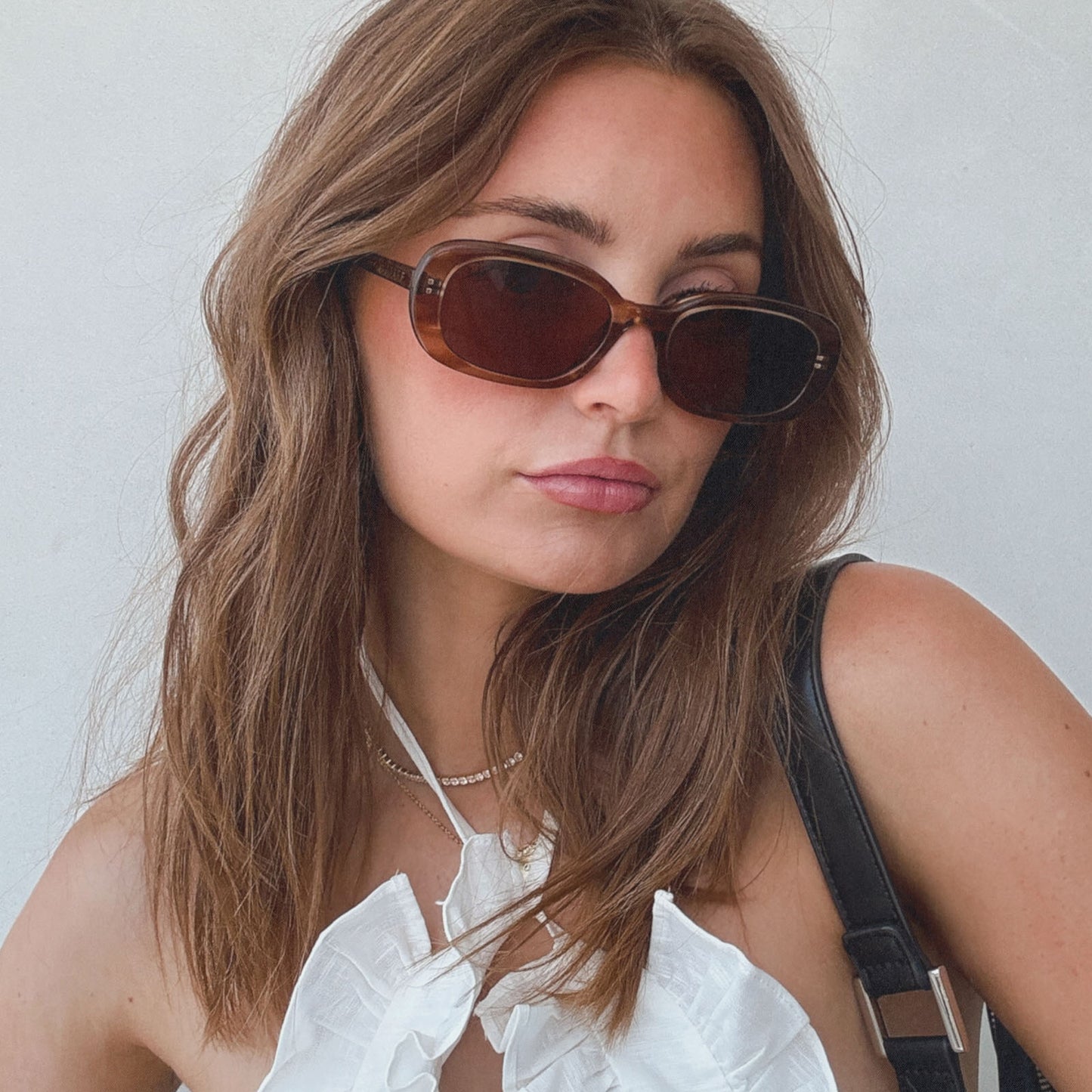 lifestyle - aspyn ovard x diff eyewear female wearing the cove oval prescription sunglasses with a tortoise frame angled view