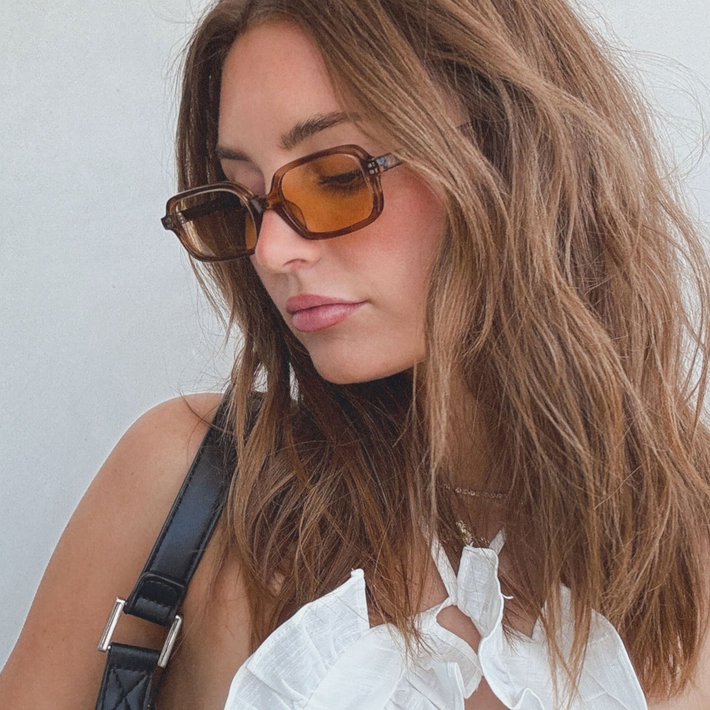 lifestyle - aspyn ovard x diff eyewear female wearing the elle rectangle sunglasses with a tortoise frame and brown tint lenses side view