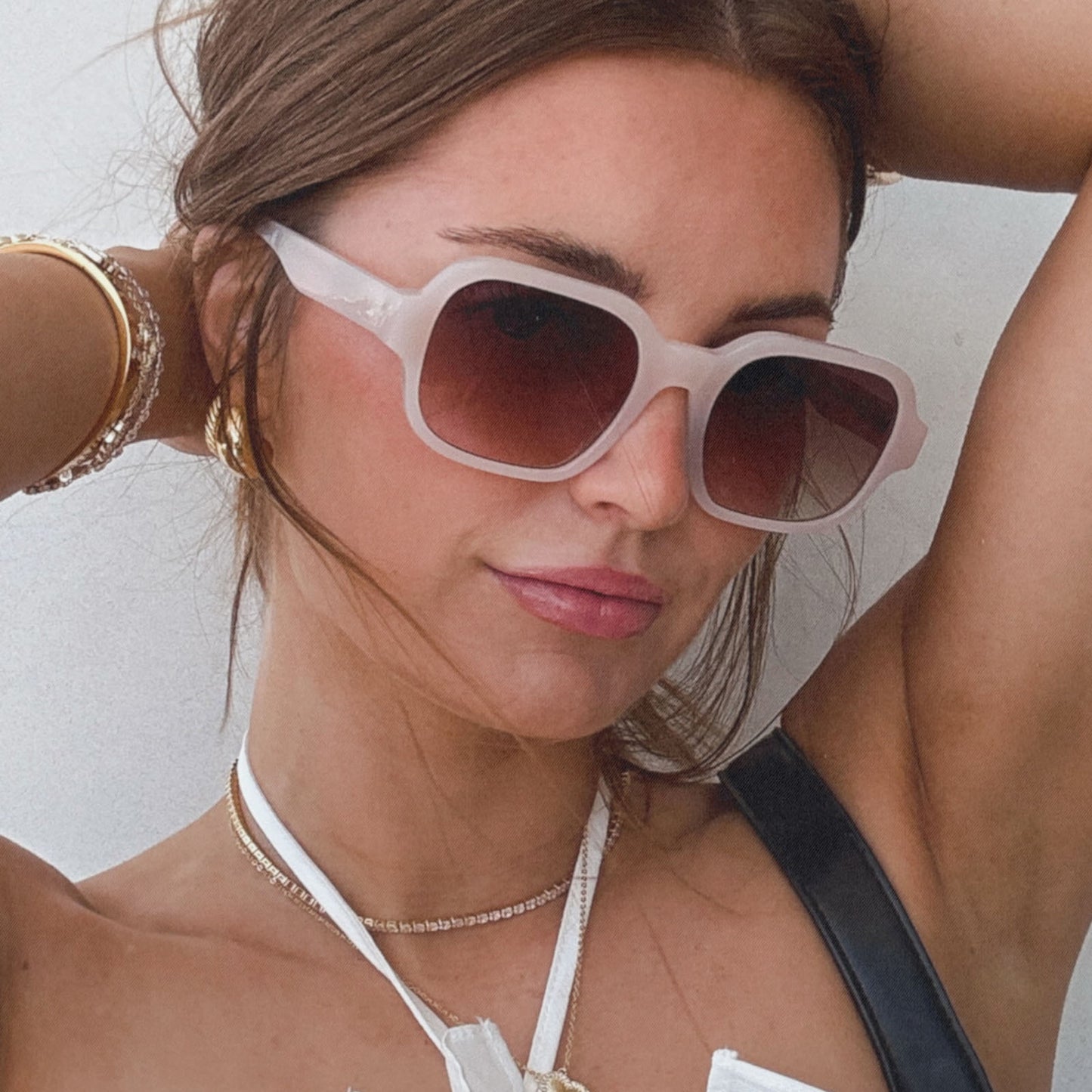 lifestyle - aspyn ovard x diff eyewear female wearing the lola square prescription sunglasses with a milky blush frame angled view