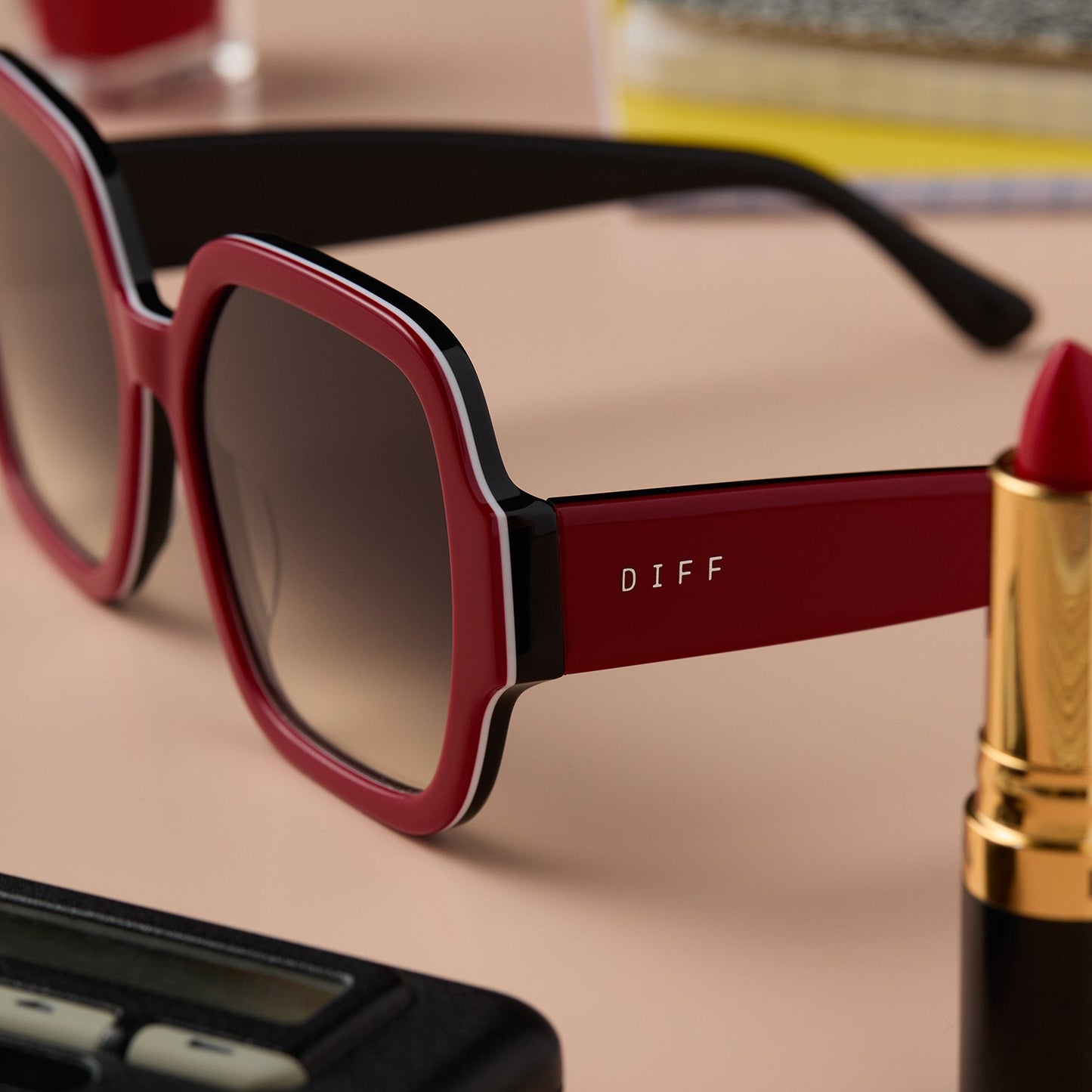 lifestyle - clueless x diff eyewear featuring the dionne square sunglasses with a red frame and grey gradient lenses detailed view