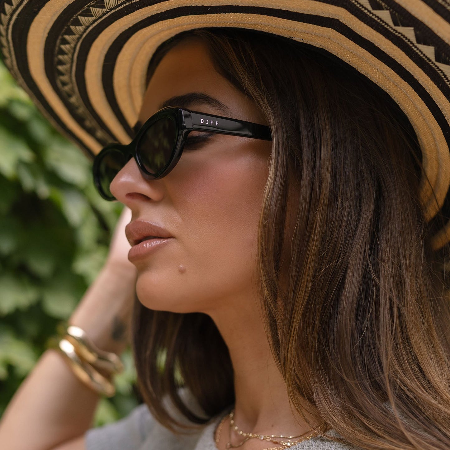 lifestyle - jjd female wearing jessie james decker x diff eyewear featuring the dolce bella oval sunglasses with a black frame and grey lenses side view