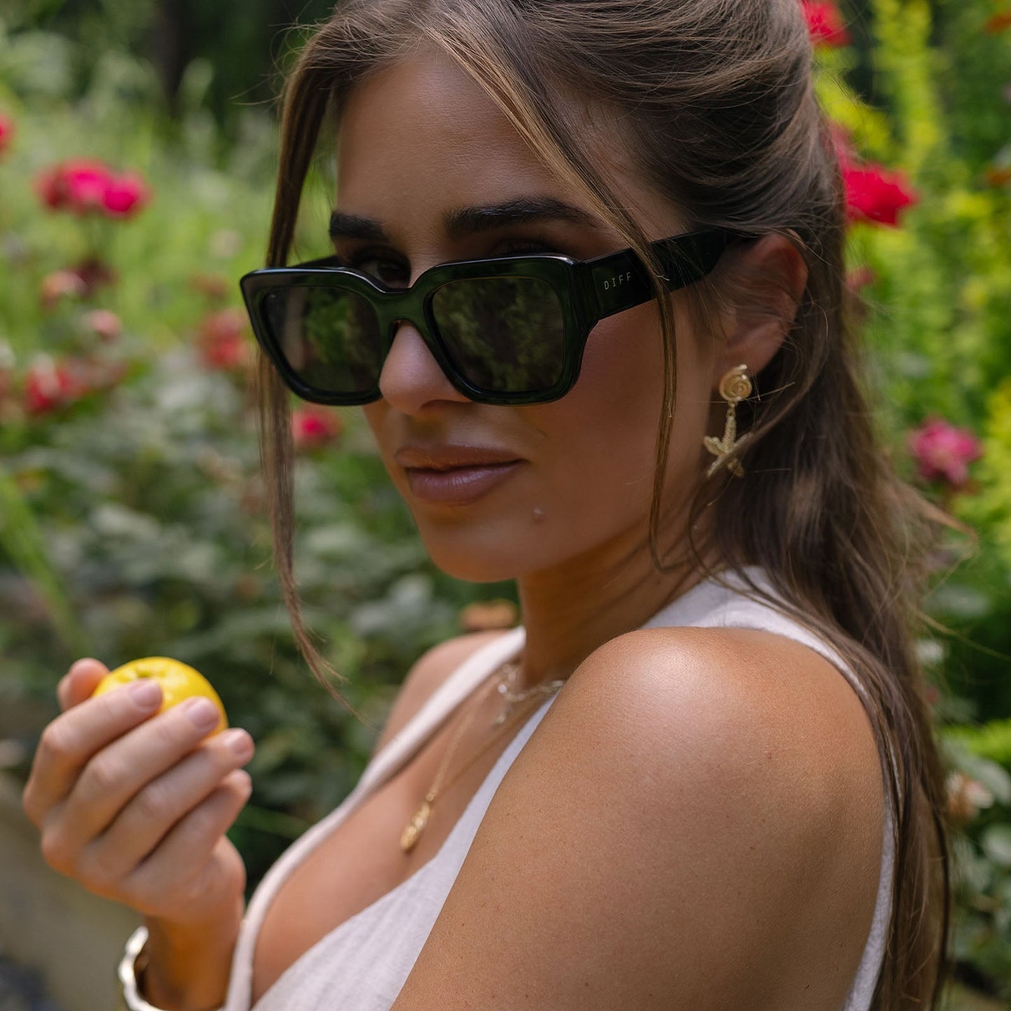 lifestyle - jessie james decker wearing diff eyewear loren square sunglasses with a black frame and grey lenses angled view