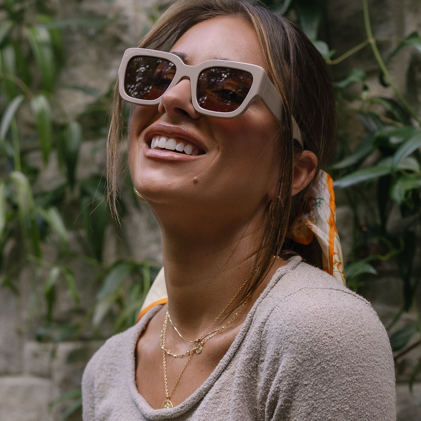 lifestyle - jessie james decker female wearing diff eyewear featuring the loren square sunglasses with a almond frame and brown lenses angled view