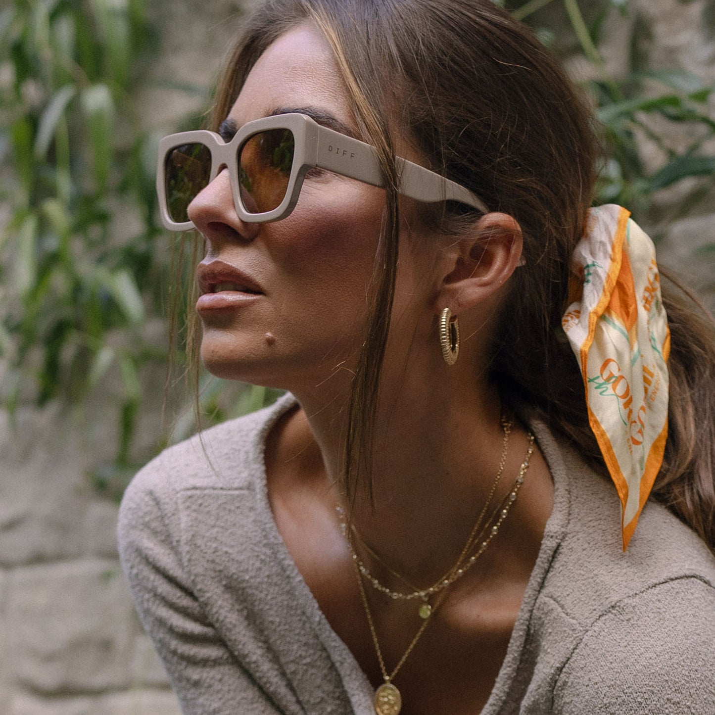 lifestyle - jessie james decker female wearing diff eyewear featuring the loren square sunglasses with a almond frame and brown lenses side view