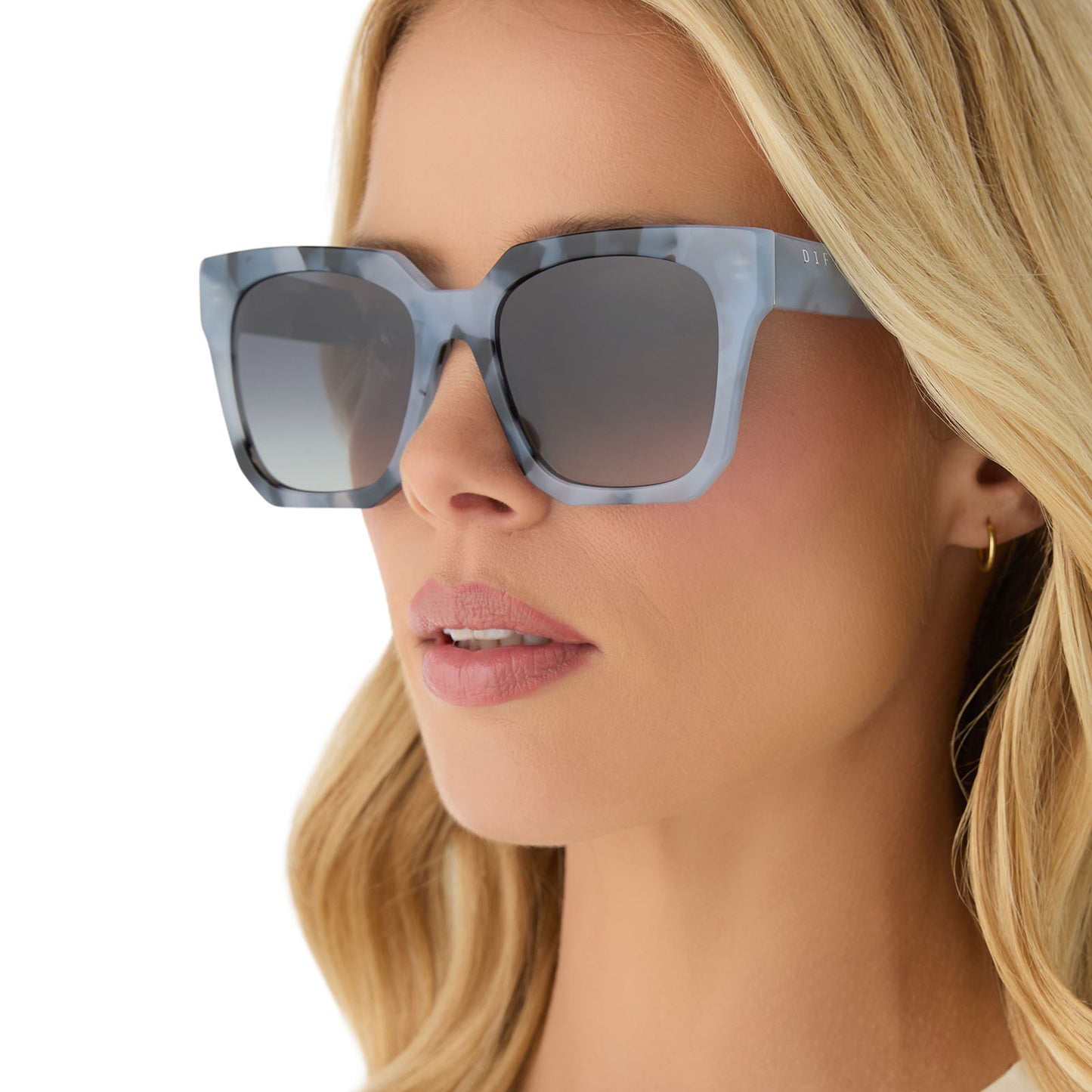 on model - female wearing diff eyewear featuring the ariana square sunglasses with a retro blue tortoise frame and grey gradient lenses angled view