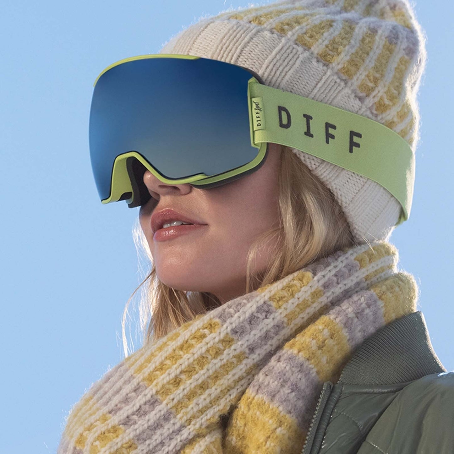 lifestyle - blonde woman wearing green and grey snow goggles