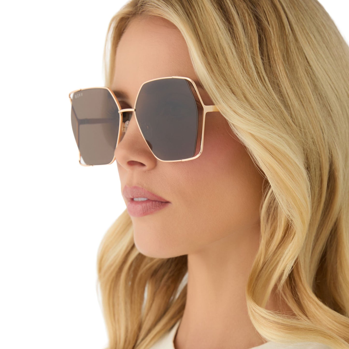 on model - female wearing diff eyewear featuring the donna iv square sunglasses with a brushed gold frame and truffle lenses side view