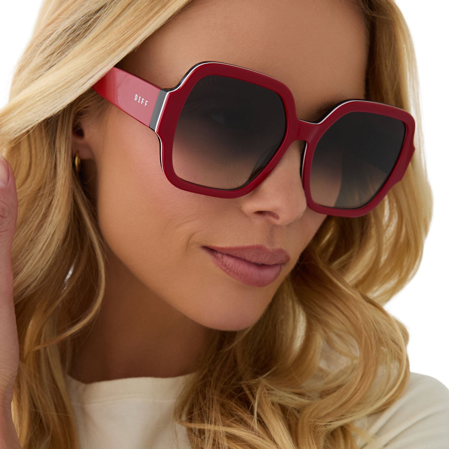 on model - female wearing clueless x diff eyewear featuring the dionne square sunglasses with a red frame and grey gradient lenses angled view