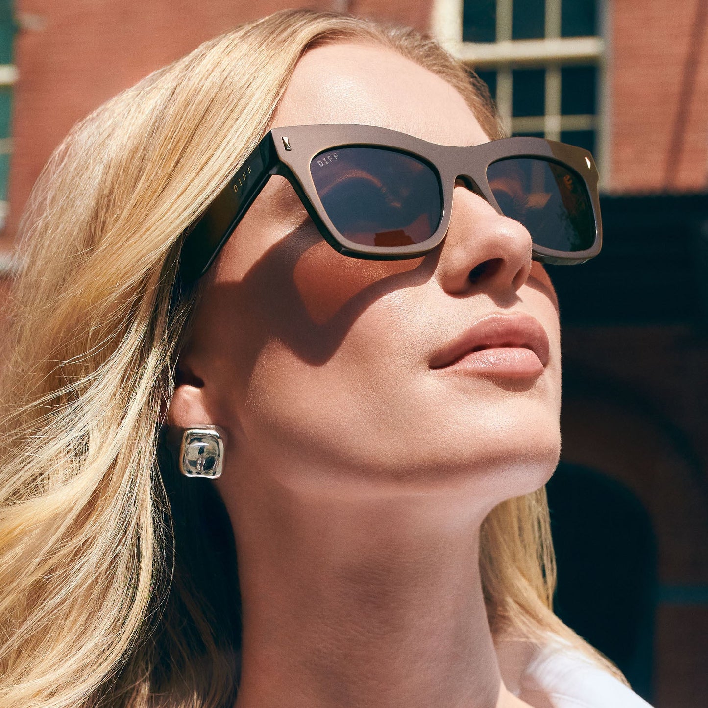 on model - female wearing on model - female wearing diff eyewear featuring the bradley cat eye sunglasses with a moscow mule frame and brown lenses angled view