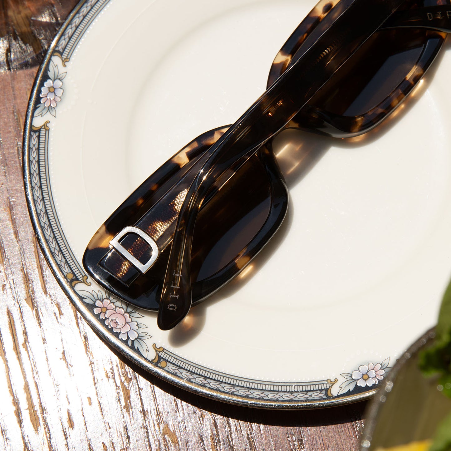 still life of diff eyewear daphne rectangle sunglasses with a espresso tortoise + metal frame and brown polarized lenses