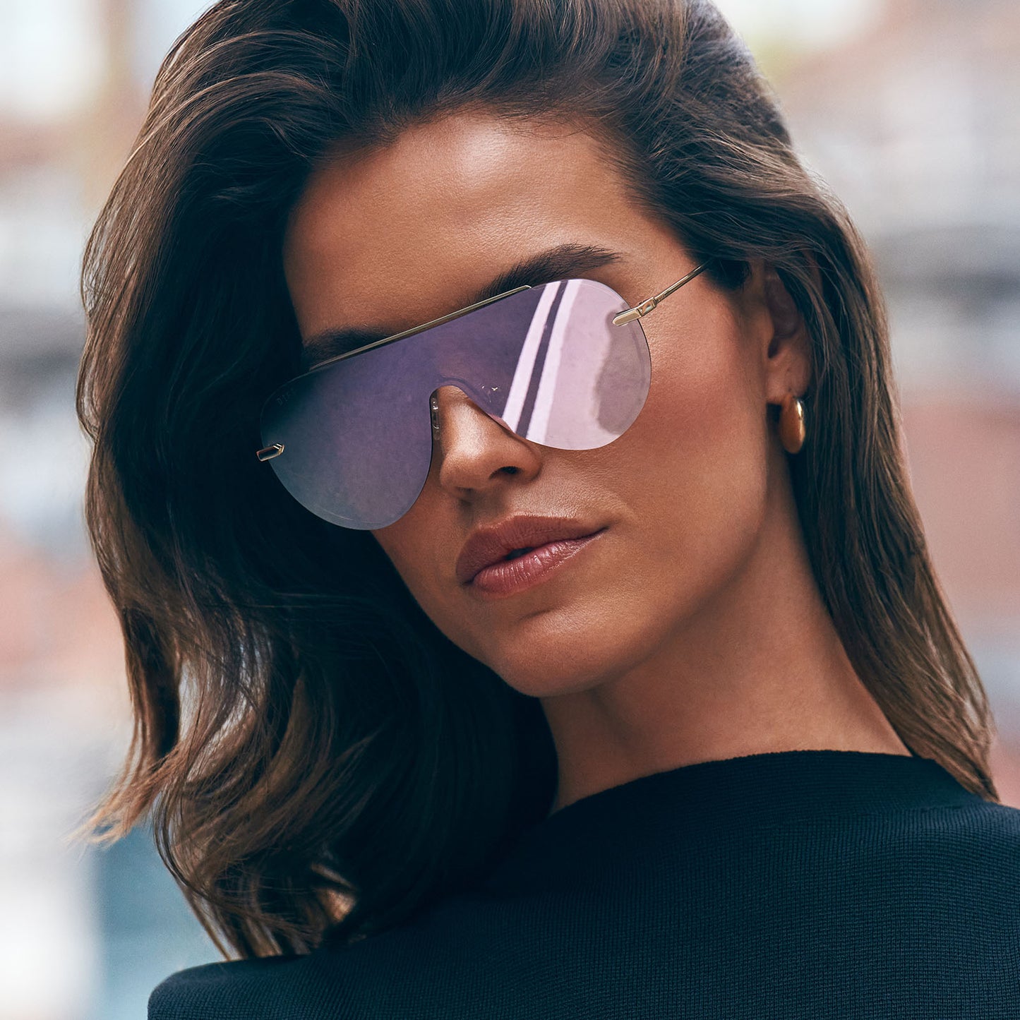on model - female wearing diff eyewear featuring the imani shield sunglasses with a gold frame and cherry blossom mirror lenses angled view