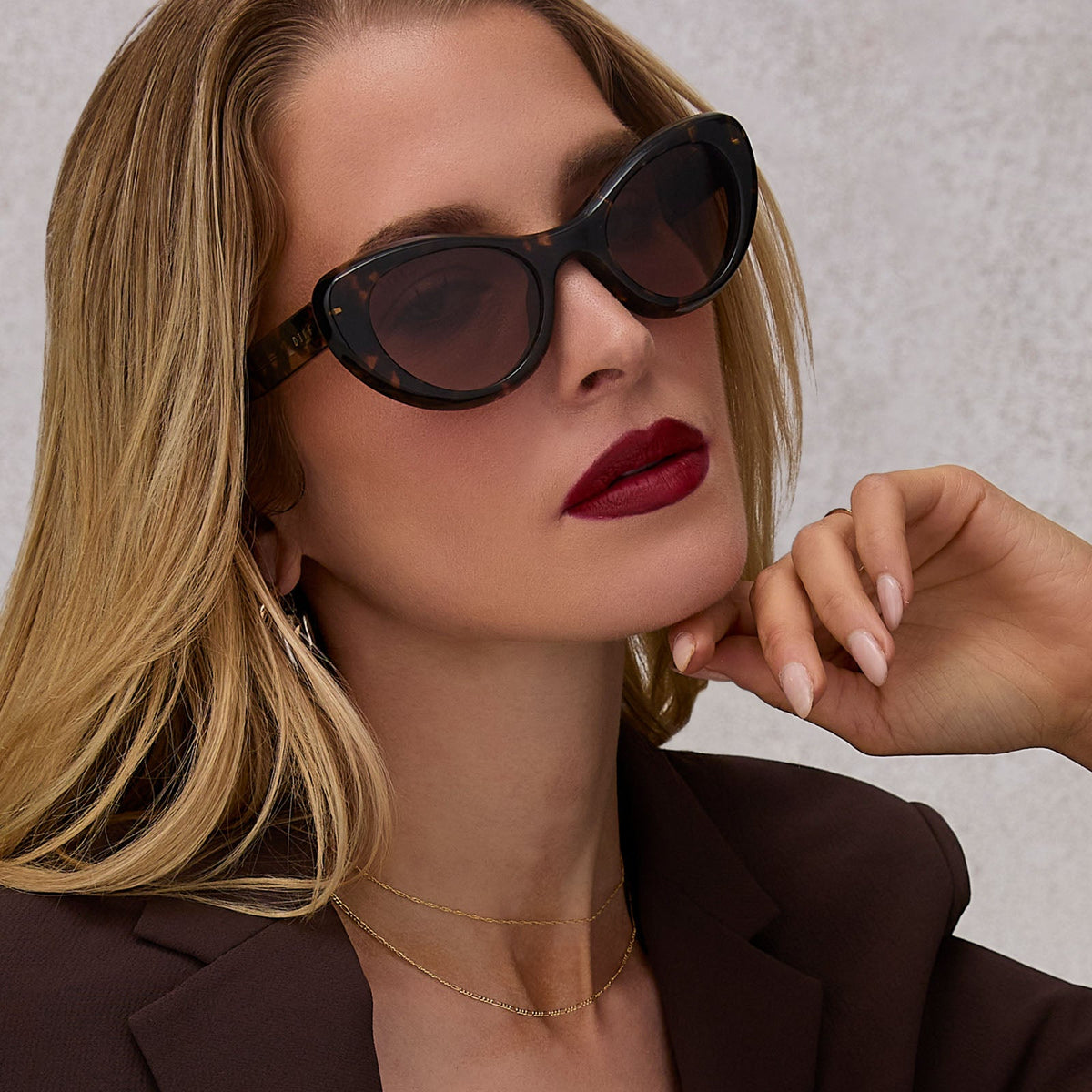 on model - female wearing diff eyewear featuring the zaria cat eye sunglasses with a espresso tortoise frame and brown gradient lenses angled view
