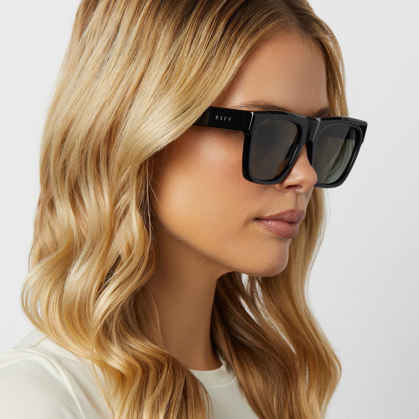 on model - blonde female wearing diff eyewear featuring the easton square sunglasses with a black frame and grey polarized lenses angled view