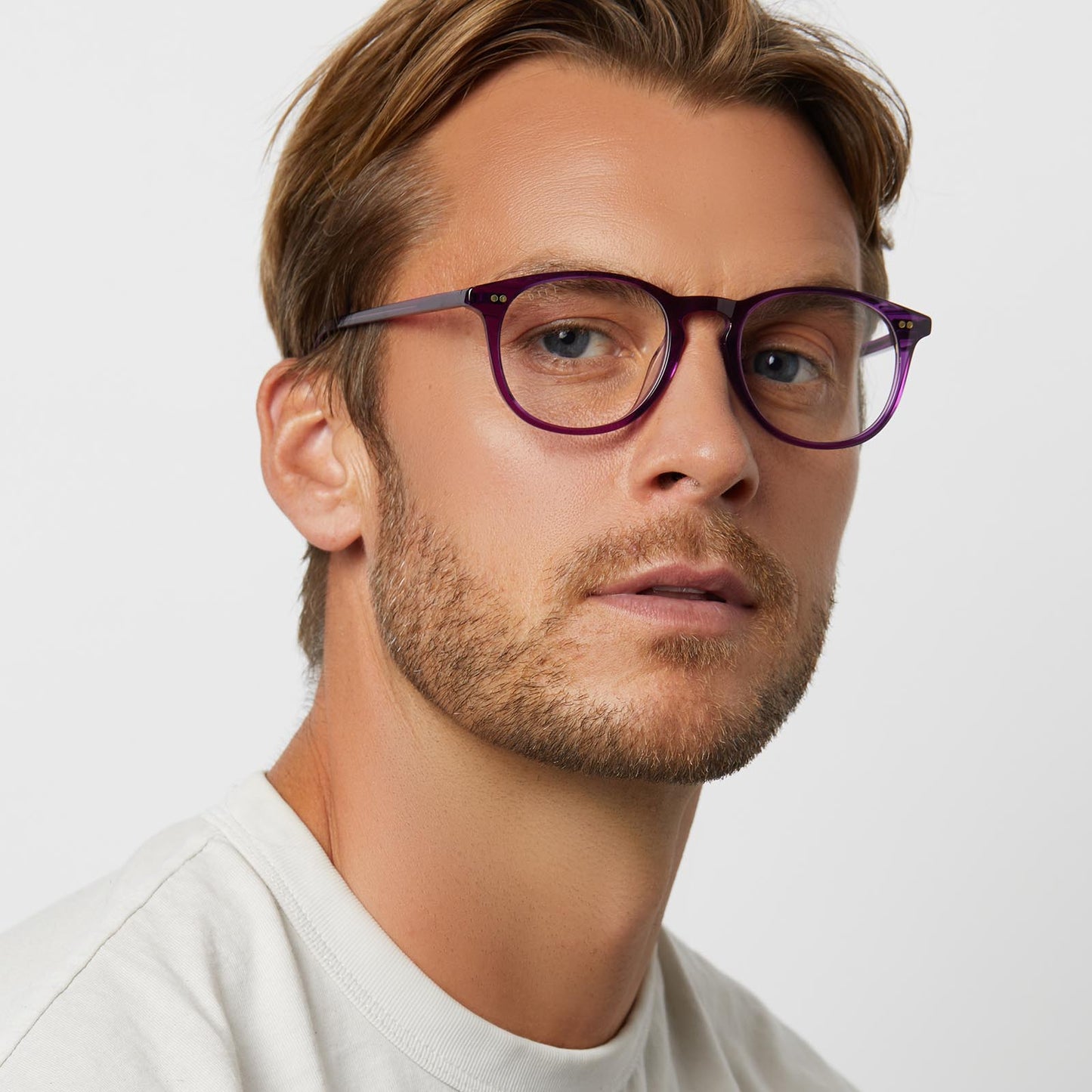 on model - male wearing diff eyewear featuring the jaxson round sunglasses with a posh purple crystal frame and clear lenses angled view