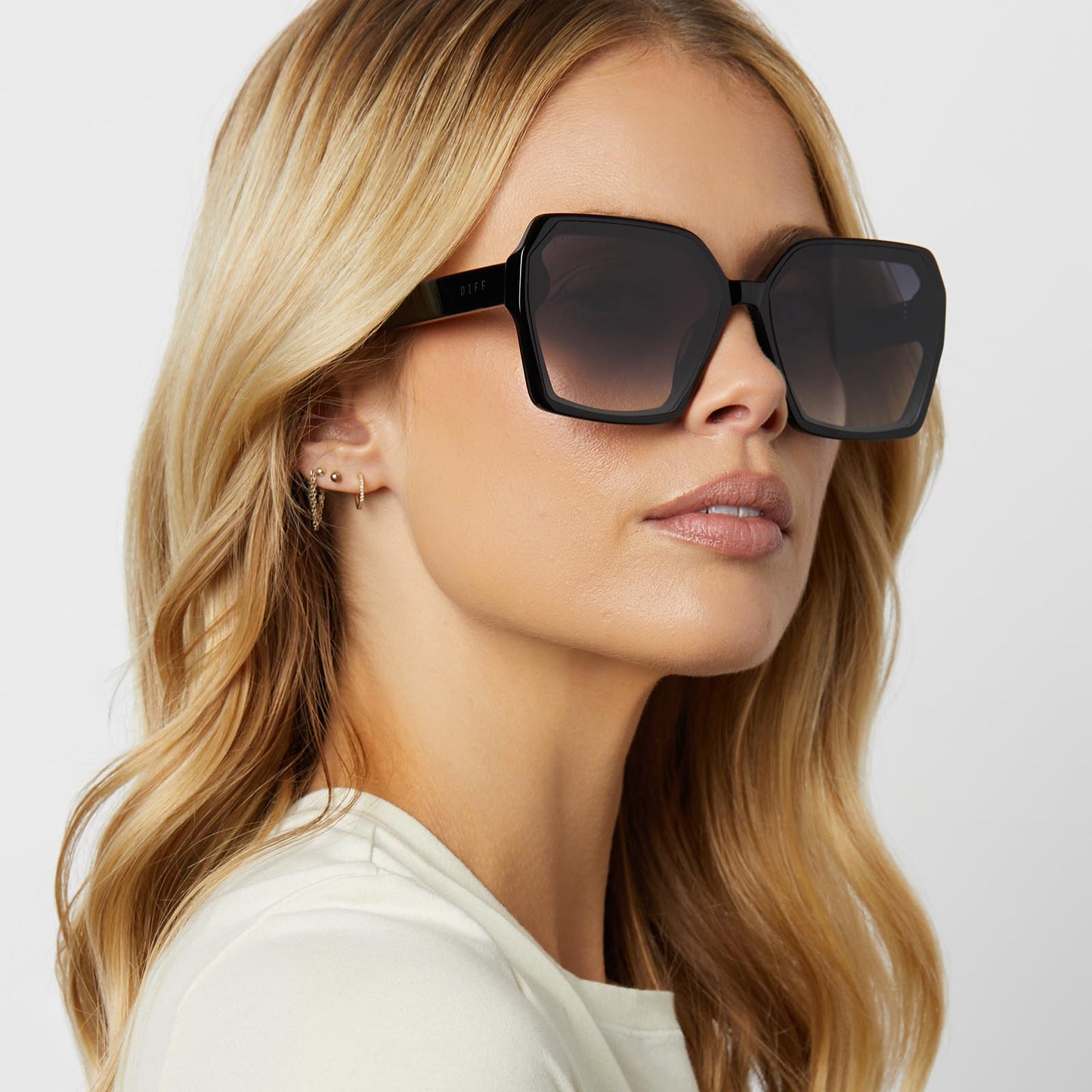 on model - blonde female wearing diff eyewear featuring the presley square sunglasses with a black frame and grey gradient lenses detailed view