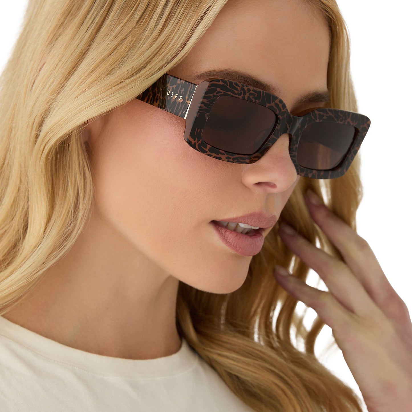 on model - female wearing diff eyewear featuring the indy rectangle sunglasses with a animal print frame and brown lenses angled view