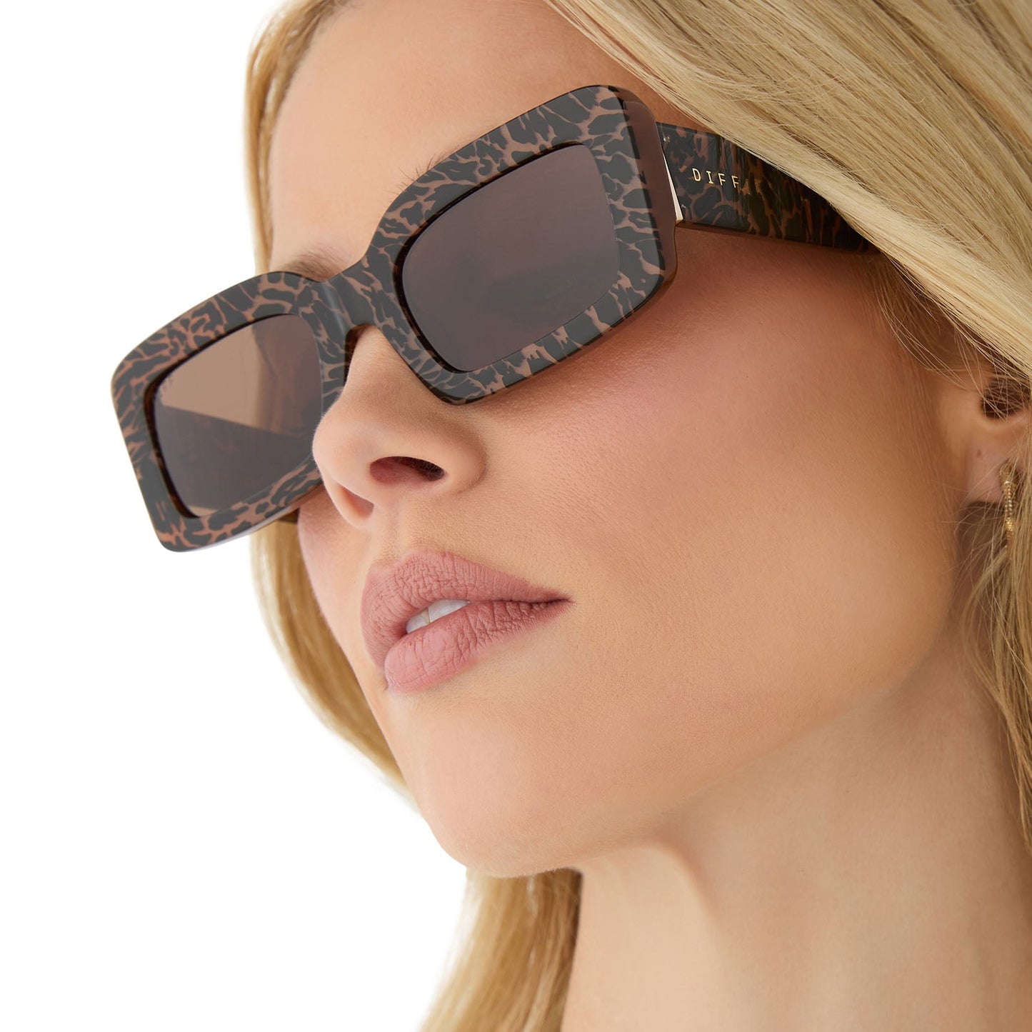 on model - female wearing diff eyewear featuring the indy rectangle sunglasses with a animal print frame and brown lenses angled view