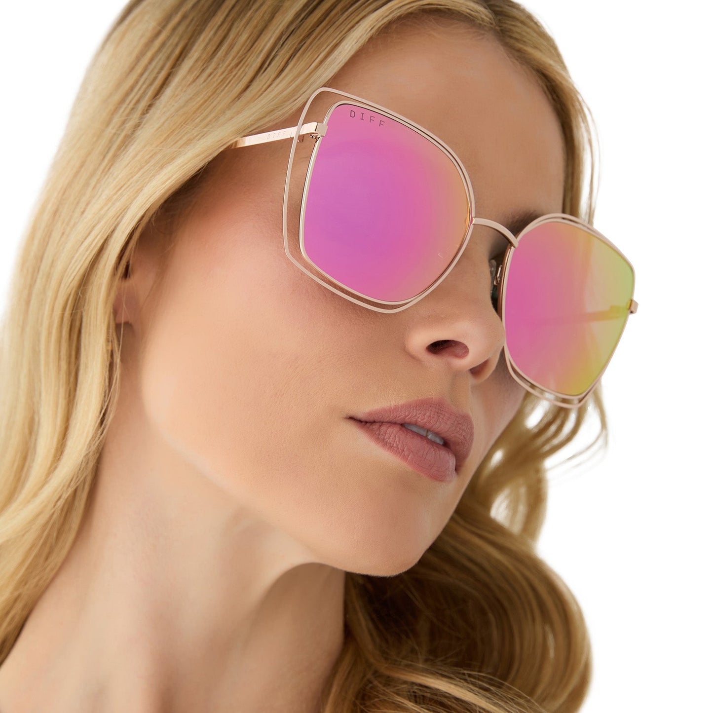 on model - female wearing diff eyewear featuring the jacqueline square sunglasses with a champagne frame and pink mirror lenses angled view