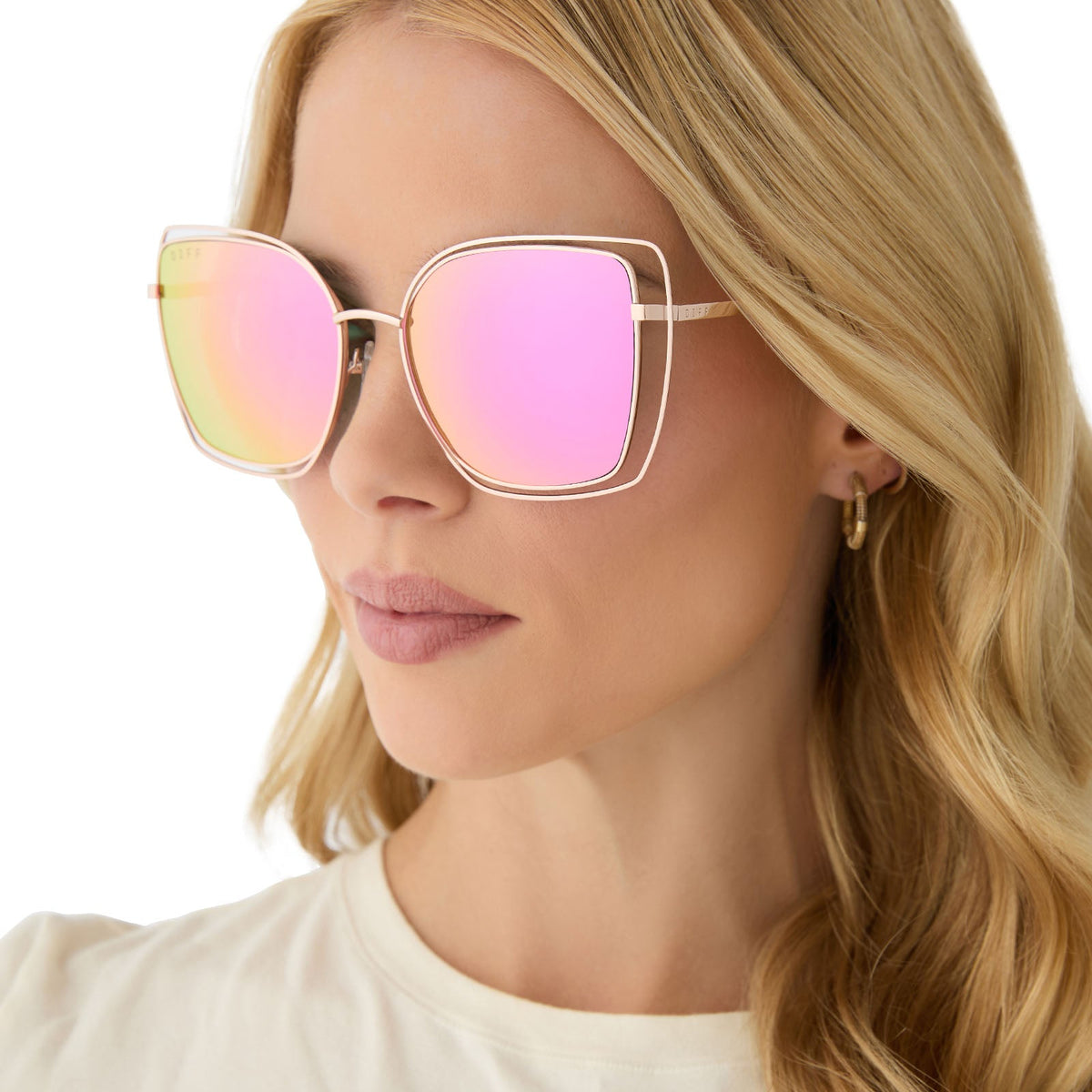 on model - female wearing diff eyewear featuring the jacqueline square sunglasses with a champagne frame and pink mirror lenses angled view