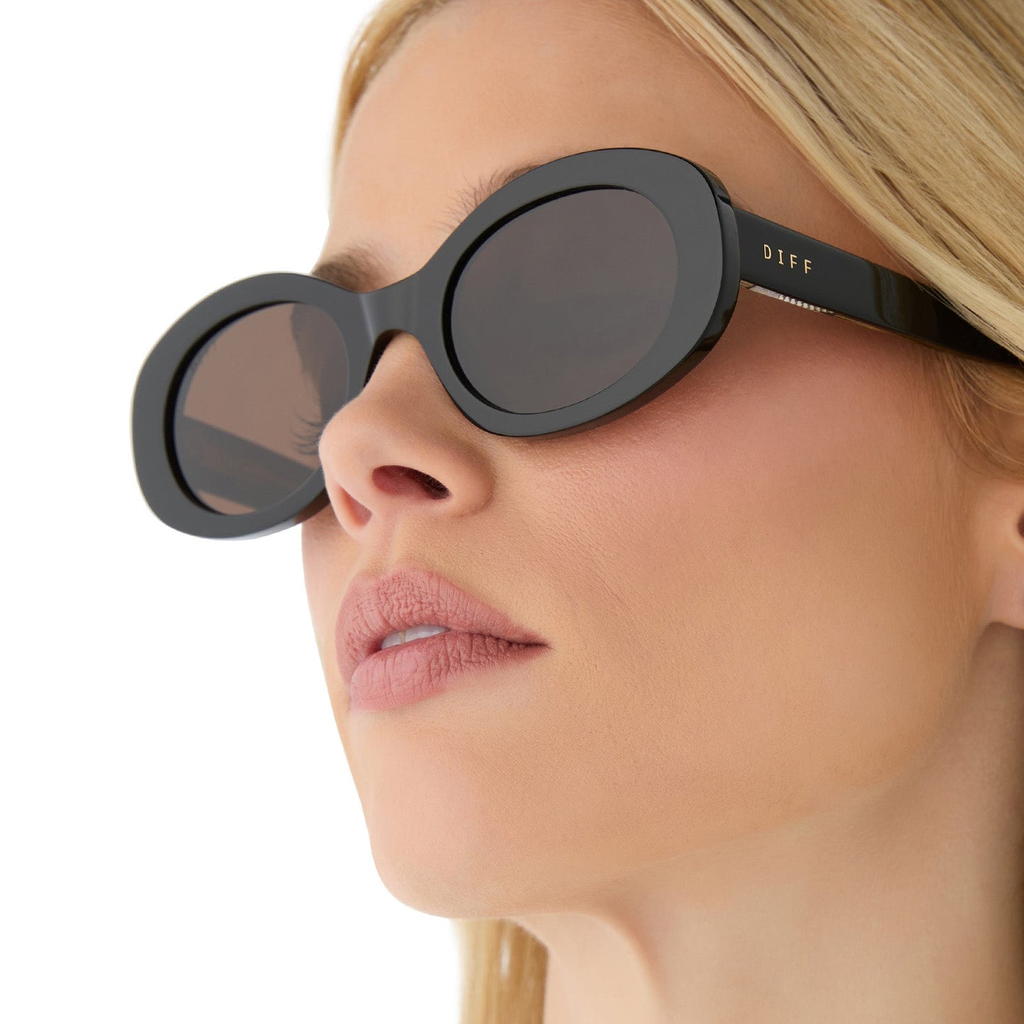 on model - female wearing diff eyewear featuring the lainey oval sunglasses with a black frame and brown polarized lenses side view