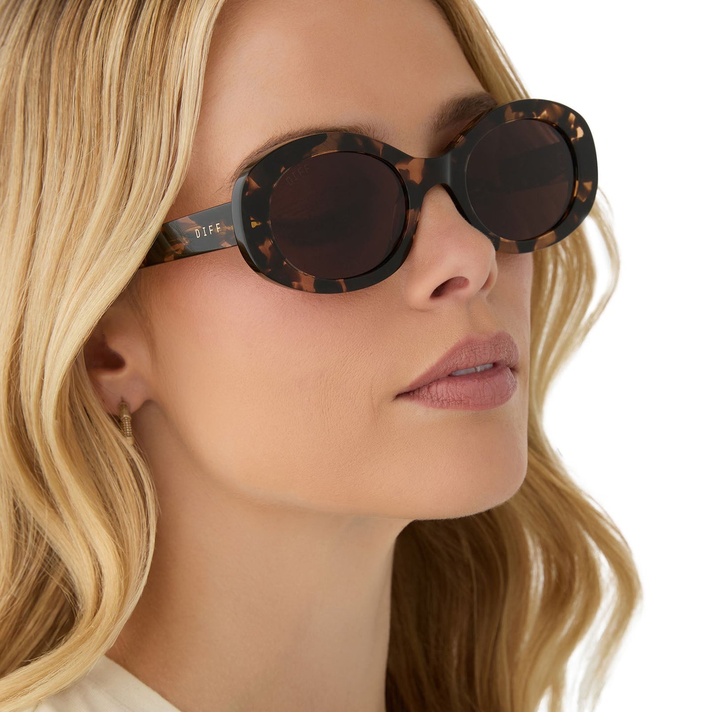 on model - female wearing diff eyewear featuring the lainey oval sunglasses with a espresso tortoise frame and brown lenses angled view