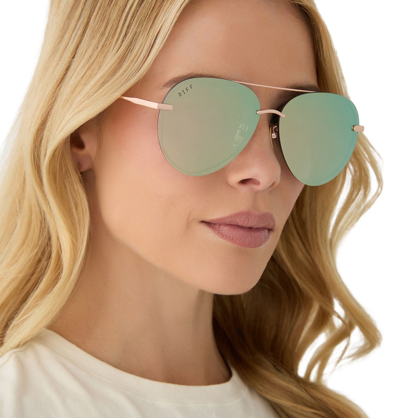 on model - female wearing diff eyewear featuring the lenox aviator sunglasses with a brushed champagne frame and cool matcha green mirror polarized lenses angled view