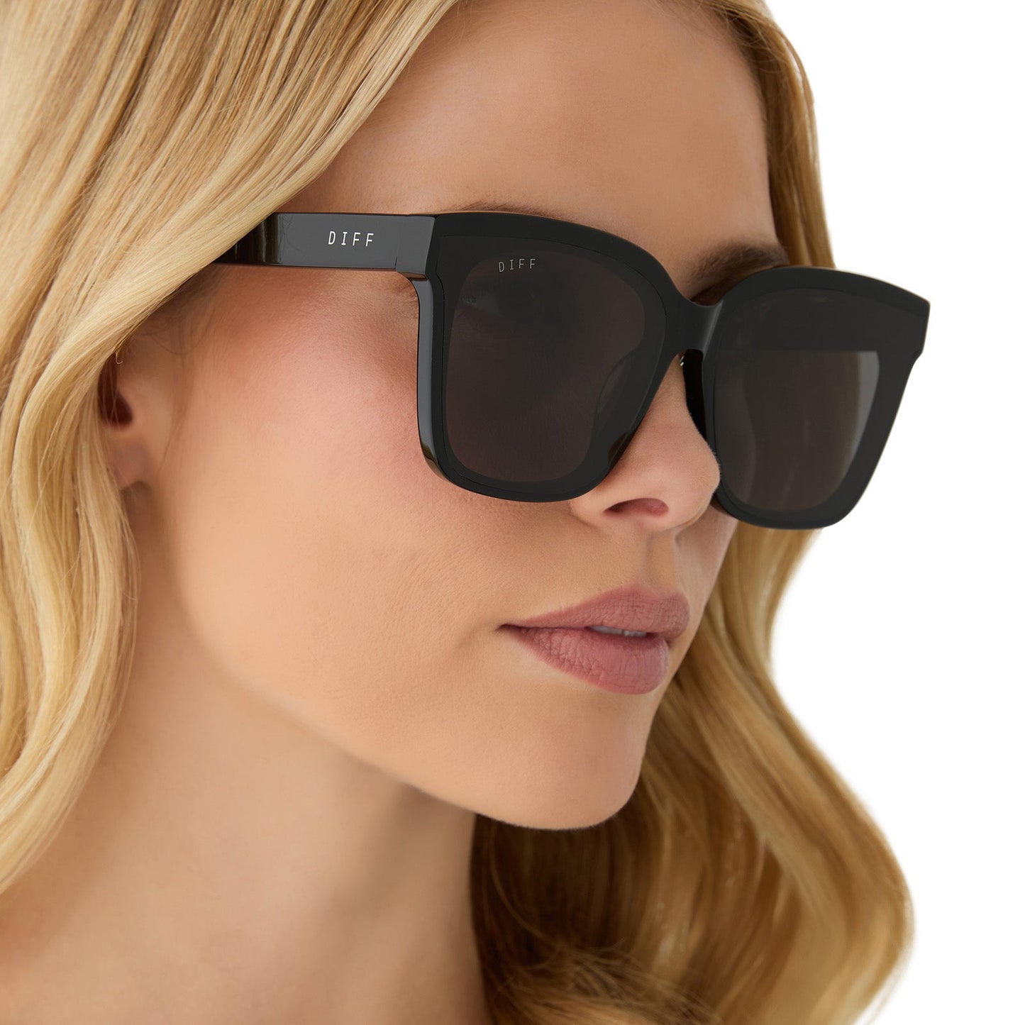 on model - female wearing diff eyewear featuring the meredith ii square sunglasses with a black frame and grey lenses side view