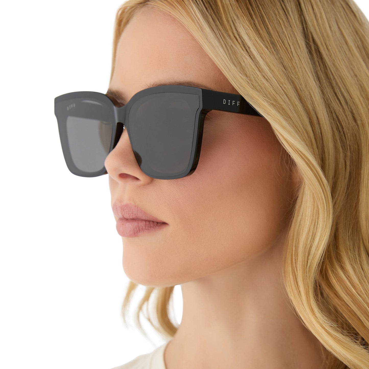 on model - female wearing diff eyewear featuring the meredith ii square sunglasses with a black frame and grey lenses angled view