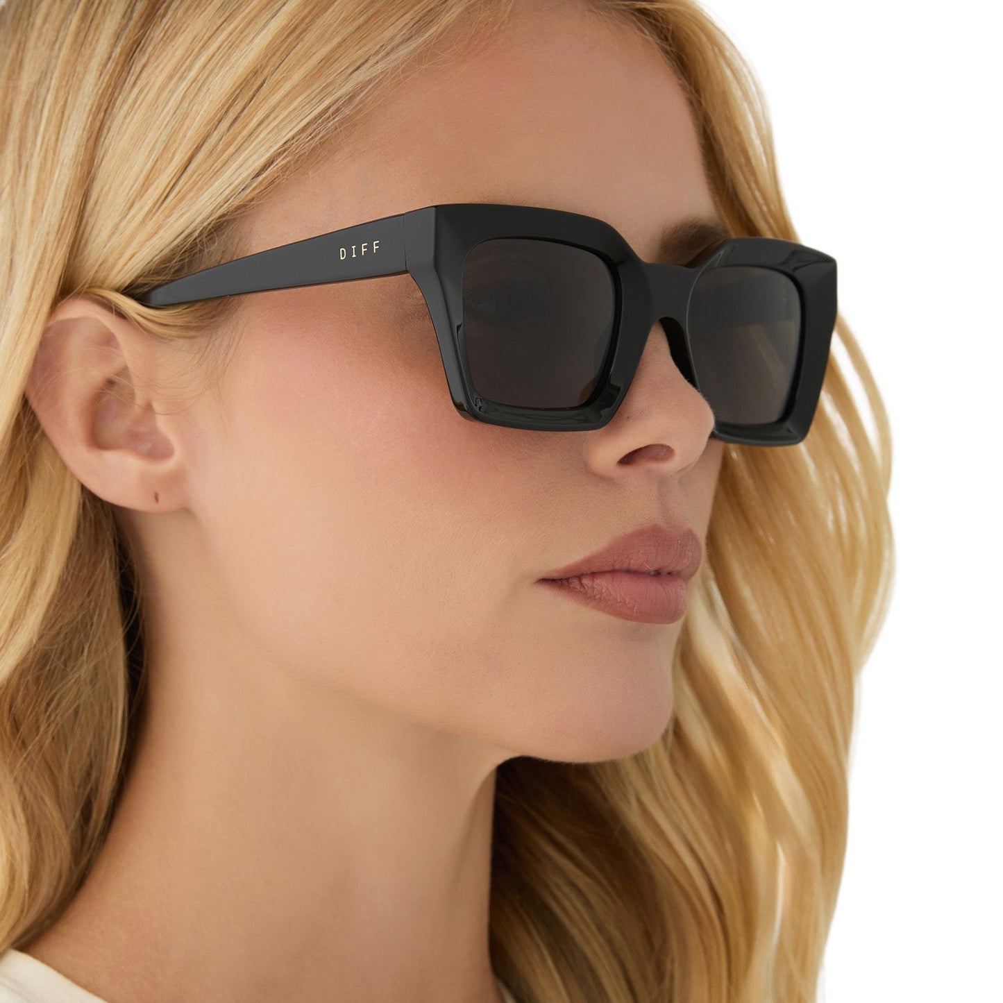 on model - female wearing diff eyewear featuring the greer square sunglasses with a black frame and grey lenses angled view