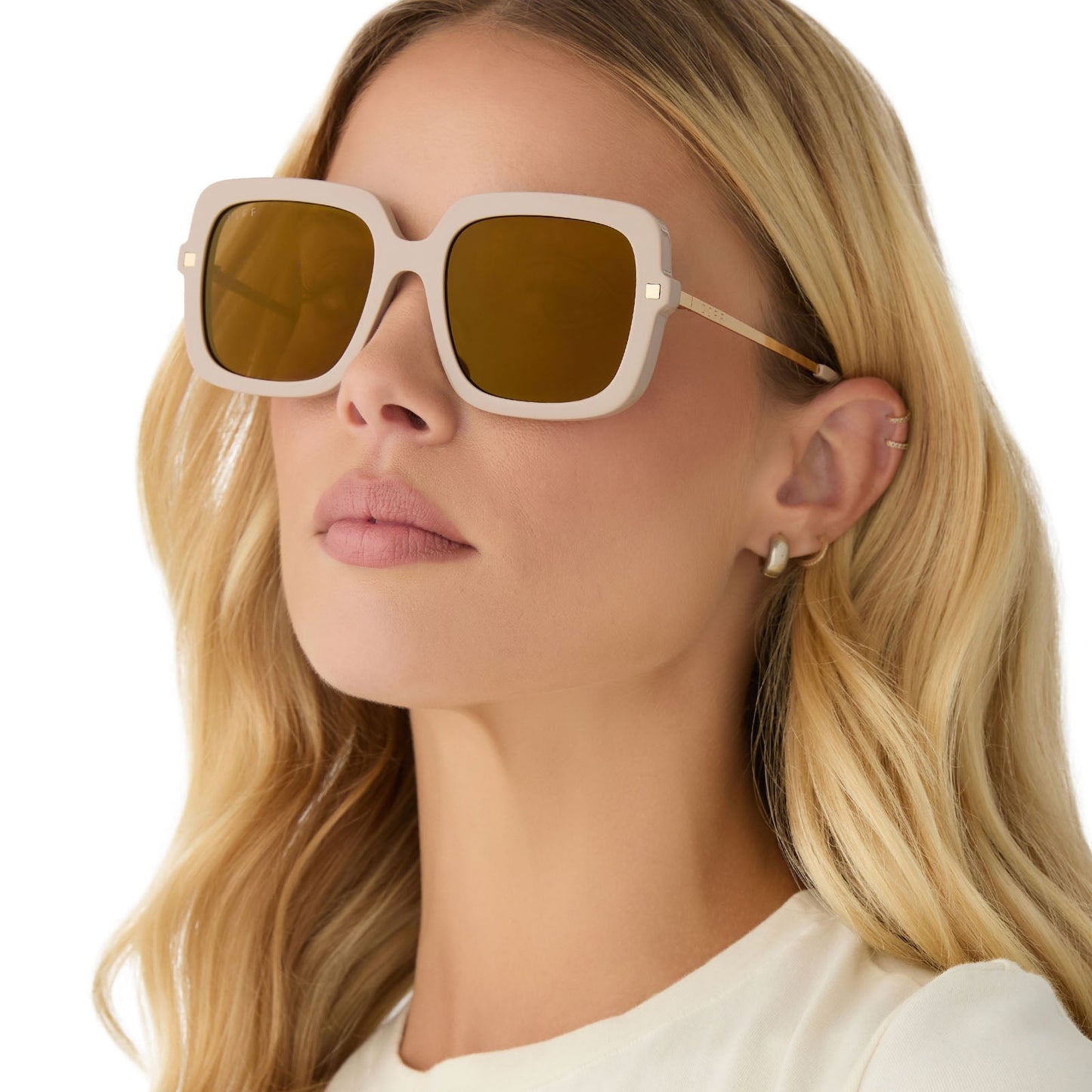 on model - female wearing diff eyewear featuring the sandra square sunglasses with a almond frame and brown gold flash lenses angled view