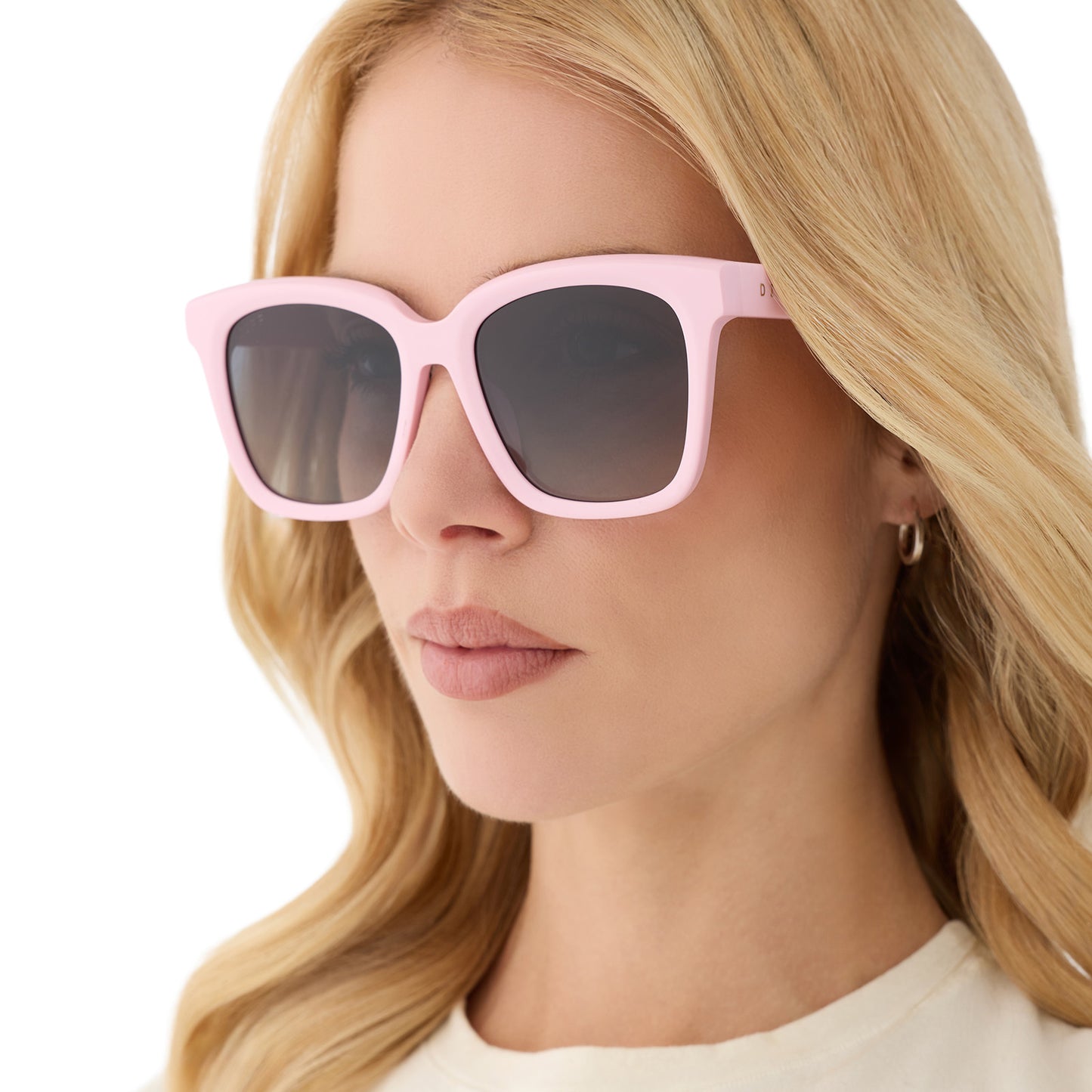 on model - female wearing diff eyewear featuring the meredith square sunglasses with a powder pink frame and grey gradient polarized lenses angled view