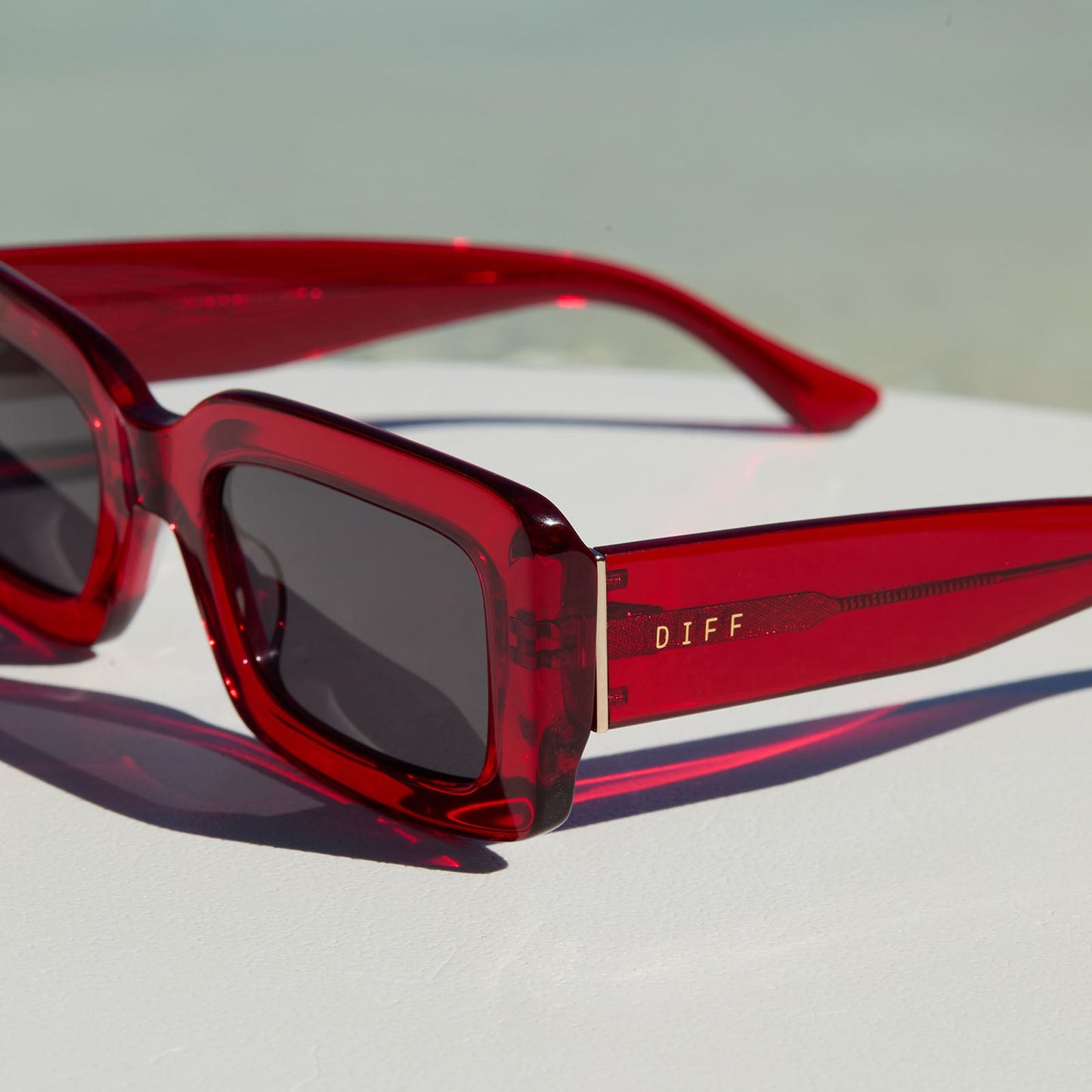 lifestyle - still life of diff eyewear indy rectangular red hot summer sunglasses