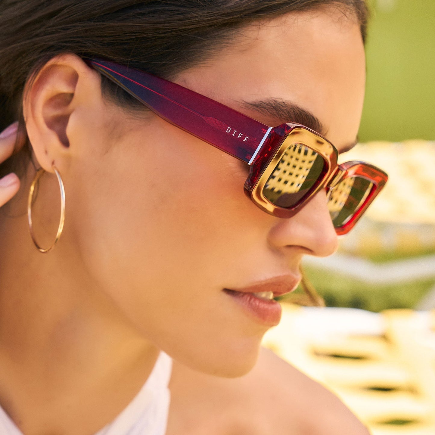 lifestyle - female wearing diff eyewear featuring the indy rectangle sunglasses with a red hot summer frame and grey polarized lenses side view