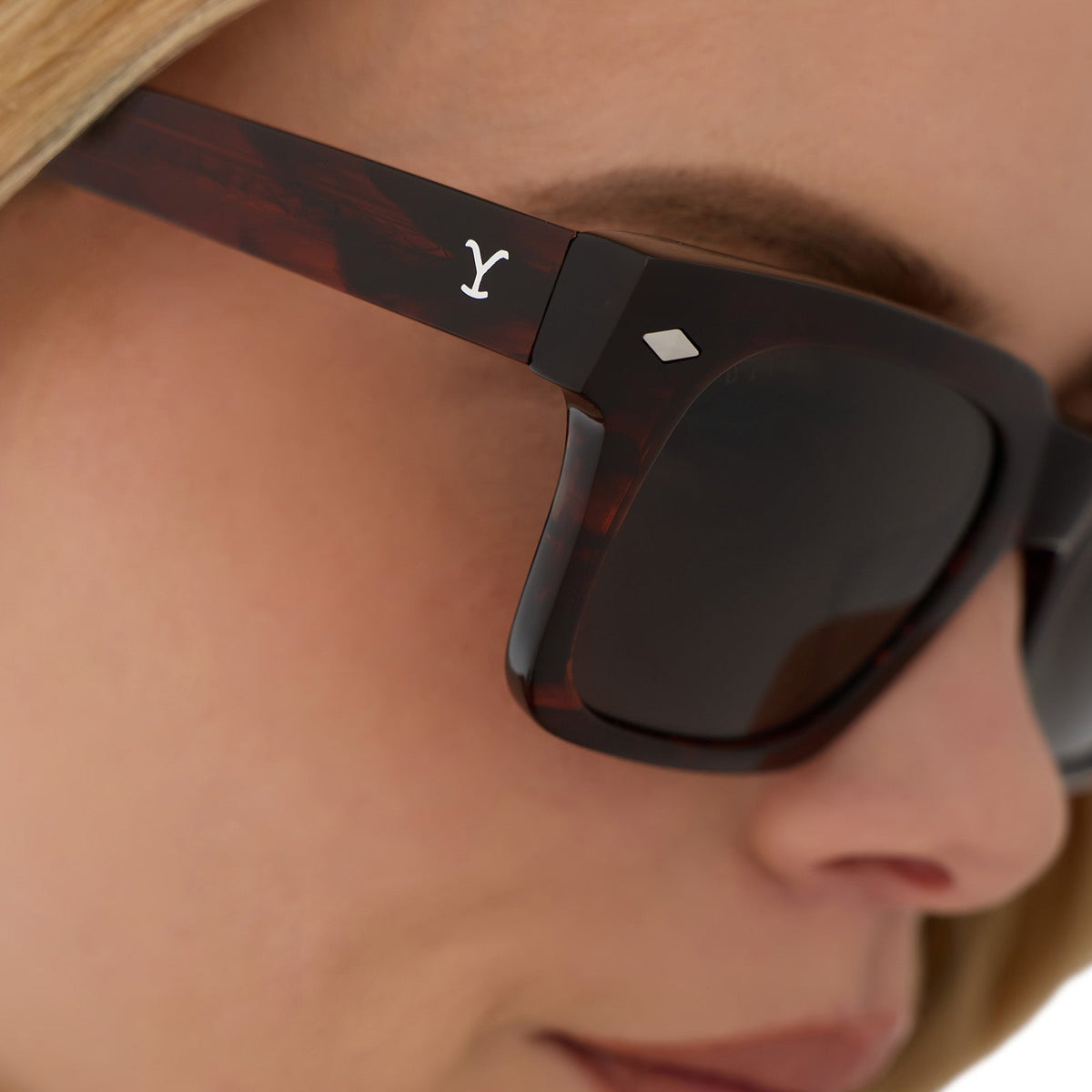 on model - blonde female wearing yellowstone x diff eyewear featuring the kayce dutton square sunglasses with a western sequoia acetate frame and green g15 polarized lenses detailed view