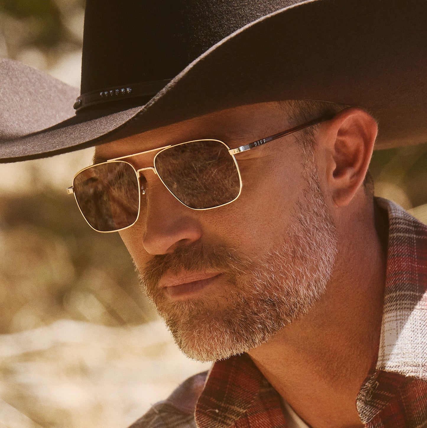 lifestyle - male wearing diff eyewear yellowstone rip wheeler sunglasses gold & brown angled view
