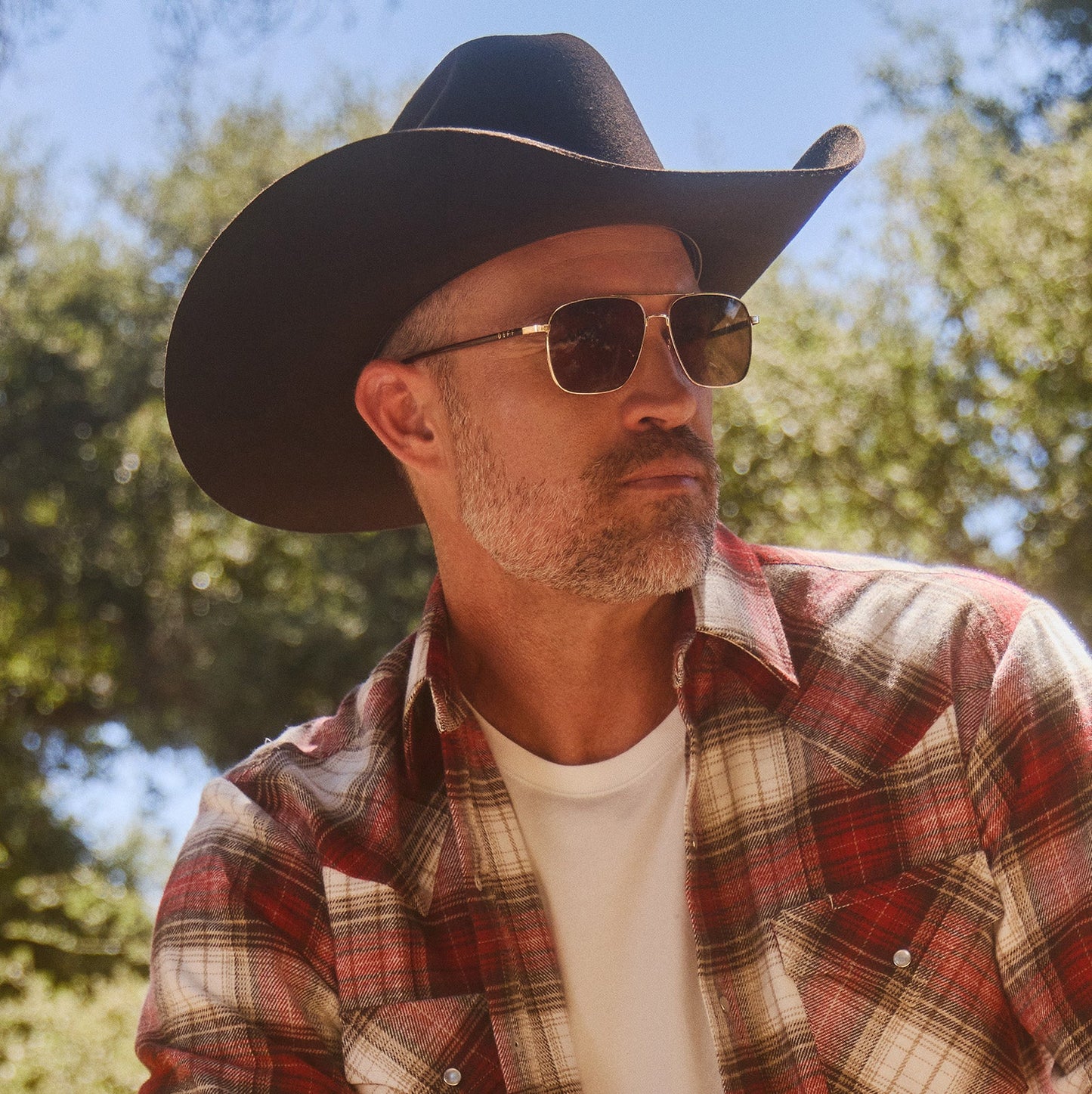 lifestyle - male wearing diff eyewear yellowstone rip wheeler sunglasses gold & brown side view