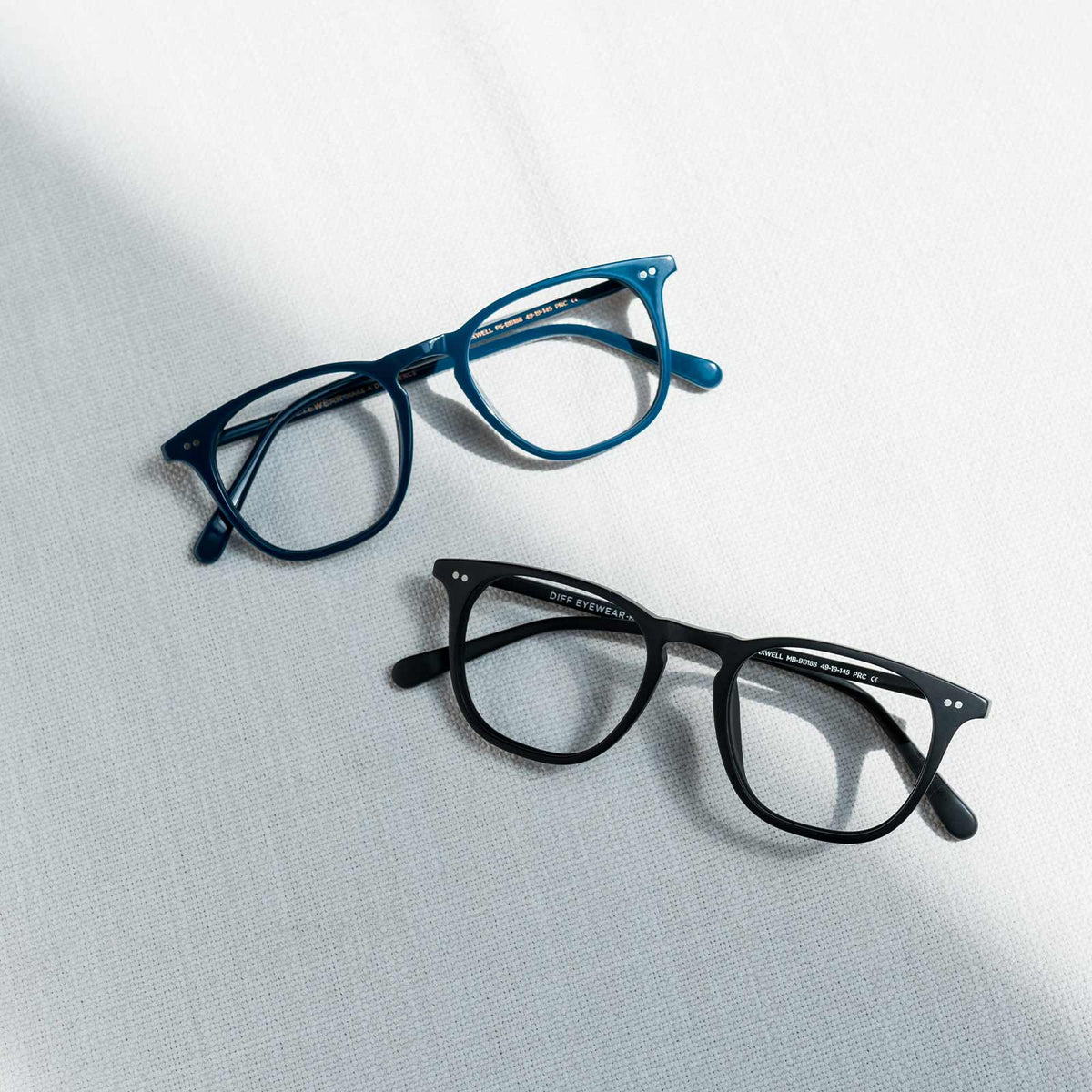 lifestyle - Flatlay Top MAXWELL - AEGEAN BLUE CRYSTAL + BLUE LIGHT TECHNOLOGY Bottom MAXWELL - MATTE BLACK + BLUE LIGHT TECHNOLOGY